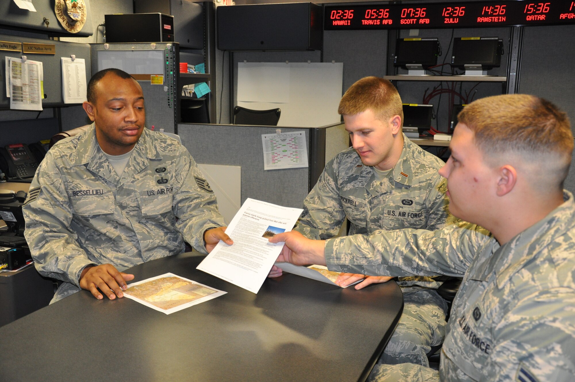 Staff Sgt. Raymond Bessellieu, 2nd Lt. Austin Pickrell, and Airman First Class Alexander Curran, AMC Air Intelligence Squadron analysts, evaluate a document obtained through research that contributed to an intelligence picture for Mobility Air Forces supporting the French intervention in Mali. The trio experienced the first crisis operation of their intelligence careers, all three having arrived at AMC within the last 12 months. (U.S. Air Force photo/Ed Shannon)