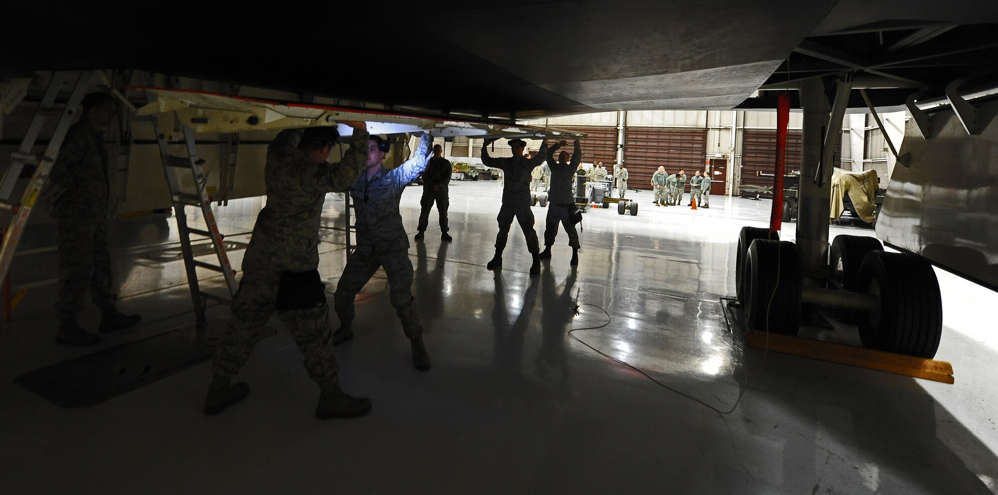 A weapons load team from the 13th Aircraft Maintenance Unit closes the weapons bay doors of a B-2 Spirit during a weapons load competition at Whiteman Air Force Base, Mo., April 12, 2013. The loaders who competed were evaluated in a multitude of areas including timeliness, reliability, safety, order errors, a 25-question written test, and a composite tool kit inspection.  (U.S. Air Force photo by Staff Sgt. Nick Wilson/Released)