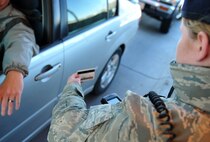 U.S. Air Force Airman 1st Class Kathryn Malone, 55th Security Forces Squadron, checks identification cards using the new Defense Biometric Identification System April 19 at the STRATCOM Gate on Offutt Air Force Base, Neb. DBIDS is a Homeland Security and Defense Department initiative developed to increase force protection and help manage personnel, property and installation access. (U.S. Air Force photo by Jeff Gates/Released)