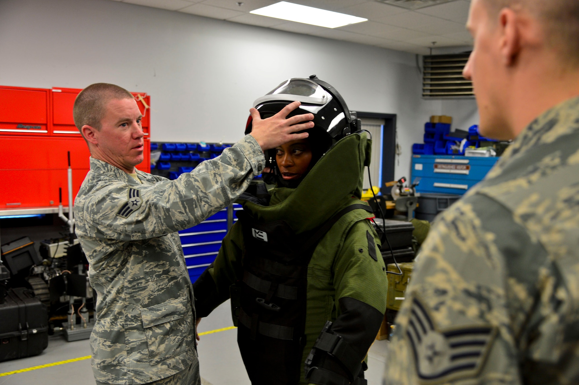Senior Airman John Nelson, left, and Staff Sgt. John Nelson, from the 436th Civil Engineer Squadron Explosive Ordnance Disposal Flight, demonstrates the EOD 9 Bomb Suit to news reporter Karen Campbell, from Dover TV station WBOC Channel 16, at Dover Air Force Base, Del.,  April 16, 2013. The Media Day was an opportunity for media representatives to get a closer look at and a better understanding of Dover AFB's EOD Airmen and mission. (U.S. Air Force photo/David S. Tucker)
