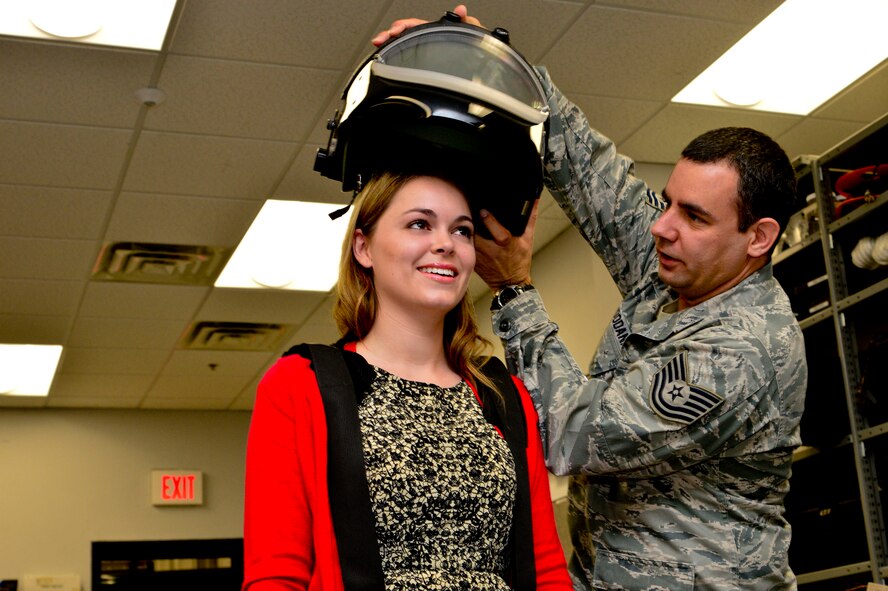 Tech Sgt. Christopher Adjoodani, from the 436th Civil Engineer Squadron Explosive Ordnance Disposal Flight, places a EOD 9 Bomb Suit helmet on news reporter Ashton Brown, from the Delaware State News, at Dover Air Force Base, Del., April 16, 2013. The Media Day was an opportunity for media representatives to get a closer look at and a better understanding of Dover AFB's EOD Airmen and mission. (U.S. Air Force photo/David S. Tucker)
