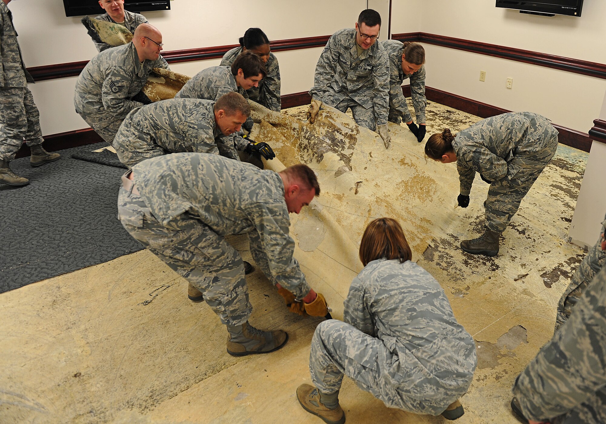 Members from Team Scott remove carpet from the basement of the 375th Air Mobility Wing headquarters building April 19, 2013 at Scott Air Force Base, Ill. Severe weather dumped 5.2 inches of rain in five hours. The basement flooded and the carpet had to be removed to prevent mildew and mold. (U.S. Air Force photo/Senior Airman Divine Cox)