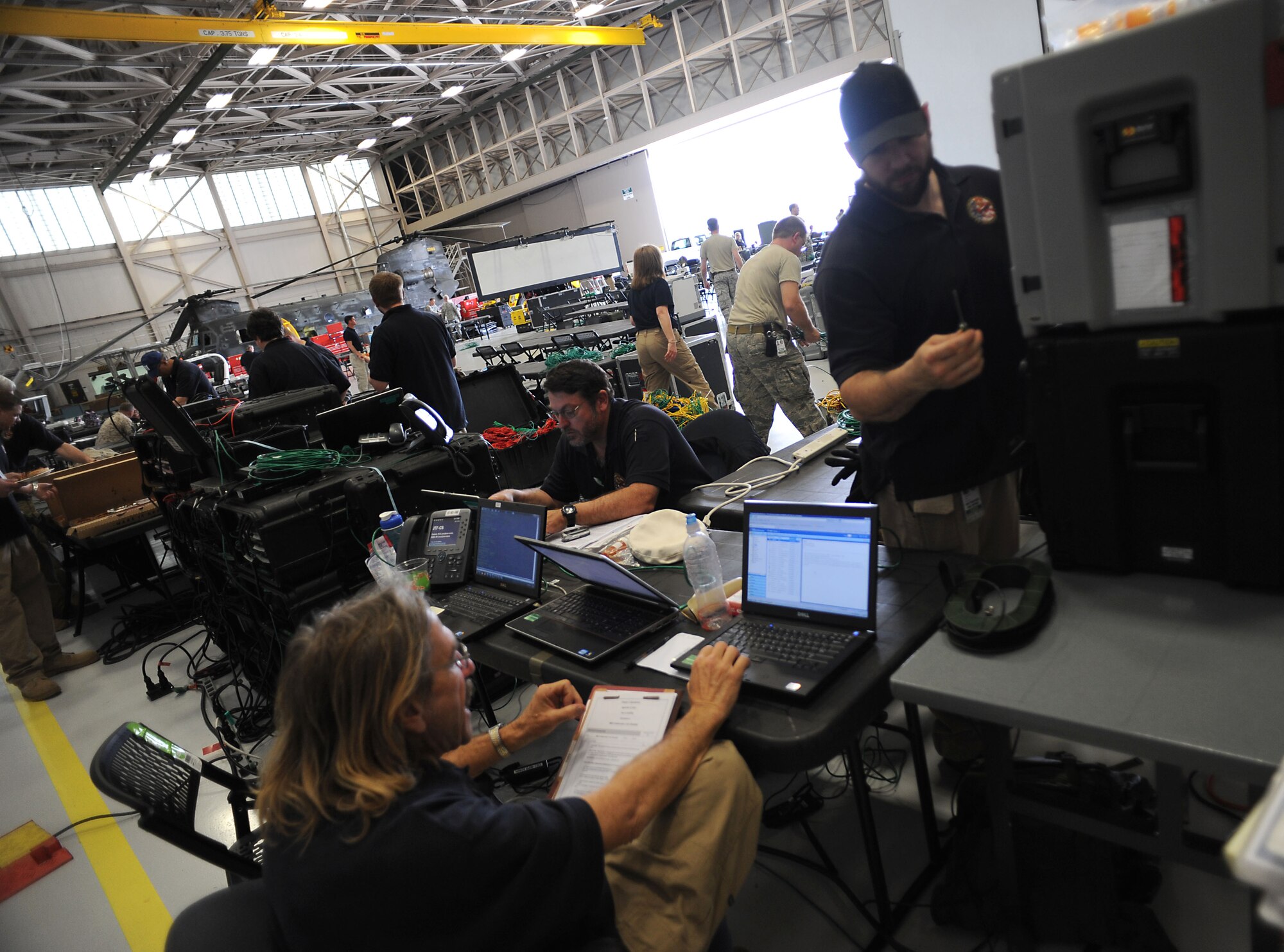 Joint Task Force Civil Support communications experts configure and test satellite communications-based network connections during a deployment readiness exercise at Fort Eustis, Va., April 16, 2013. Staff members from JTF-CS tested the unit's ability to rapidly respond to a catastrophic event, such as a chemical spill or nuclear detonation, in the U.S. as part of the four-day exercise. (Department of Defense photo by Marine Corps Gunnery Sgt. Jim Goodwin/Released)