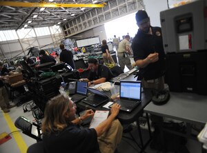 Joint Task Force Civil Support communications experts configure and test satellite communications-based network connections during a deployment readiness exercise at Fort Eustis, Va., April 16, 2013. Staff members from JTF-CS tested the unit's ability to rapidly respond to a catastrophic event, such as a chemical spill or nuclear detonation, in the U.S. as part of the four-day exercise. (Department of Defense photo by Marine Corps Gunnery Sgt. Jim Goodwin/Released)