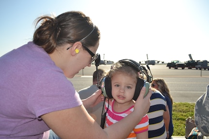 Doary, wife of Tech. Sgt. Marc Disbrow 437th Aircraft Maintenance Squadron Communication and Navigation Systems craftsman, places protective gear on her daughter Izzy during the 437th Aircraft Maintenance Squadron Spouses Tour, April 10, 2013 at Joint Base Charleston – Air Base, S.C.  The tour included informative briefings on AMXS, JB Charleston, C-17 Globemaster III capabilities and also consisted of various maintenance equipment set-up to include an aircraft tow vehicle, a bread truck (vehicle used to shuttle personnel around the flightline), and a tire chariot. (U.S. Air Force photo/ Tech. Sgt. Marc Disbrow)