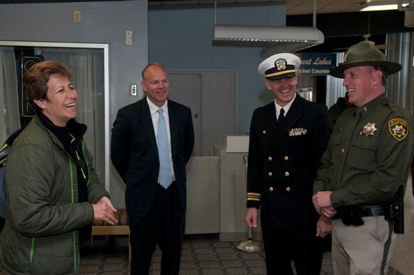Petty Officer 1st Class Regina Schulmeister, left, is greeted by Wyo. Gov. Matt Mead; Navy Lt. Cmdr. Chad Tidwell, Navy Operational Support Center Cheyenne commanding officer; and Lt. Kelly Finn, Wyoming Highway Patrol, at Cheyenne Regional Airport as she returns home April 2 from a one-year deployment. Schulmeister, a hospital corpsman reservist attached to Naval Hospital Bremerton, Wash., spent a year on active duty in Germany. In her civilian life, she is a trooper with the Wyoming Highway Patrol residing in Elk Mountain, Wyo. (U.S. Air Force photo by R.J. Oriez)