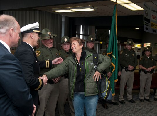 Navy Lt. Cmdr. Chad Tidwell, Navy Operational Support Center Cheyenne commanding officer, greets Petty Officer 1st Class Regina Schulmeister at the Cheyenne Regional Airport as she returns home after her long trip back from a one-year deployment April 2. Wyoming Gov. Matt Mead, her Wyoming Highway Patrol coworkers — Schulmeister is a reservist who also works for the Wyoming Highway Patrol — and NOSC-Cheyenne shipmates welcome her back stateside. Schulmeister put her civilian life on hold to serve overseas as a Navy Hospital Corpsman at the Army Regional Medical Center in Landstuhl, Germany. While there, she was awarded multiple medals for providing care to the wounded warriors returning from Iraq and Afghanistan. She was awarded the Army Commendation Medal for her tour of duty, the Army Achievement Medal for being named the 2012 Sailor of the Year at the joint hospital and the Outstanding Volunteer Service Medal for her off-duty hours escorting and chaperoning wounded warriors on morale field trips and activities. She even escorted one wounded warrior to visit the French Resistance Memorial and Sturhoff Camp, the only former Nazi Concentration Camp in France. Upon her return, Schulmeister said it was special having both of her families there welcoming her home: the Wyoming State Patrol and the U.S. Navy. (U.S. Air Force photo by R.J. Oriez)