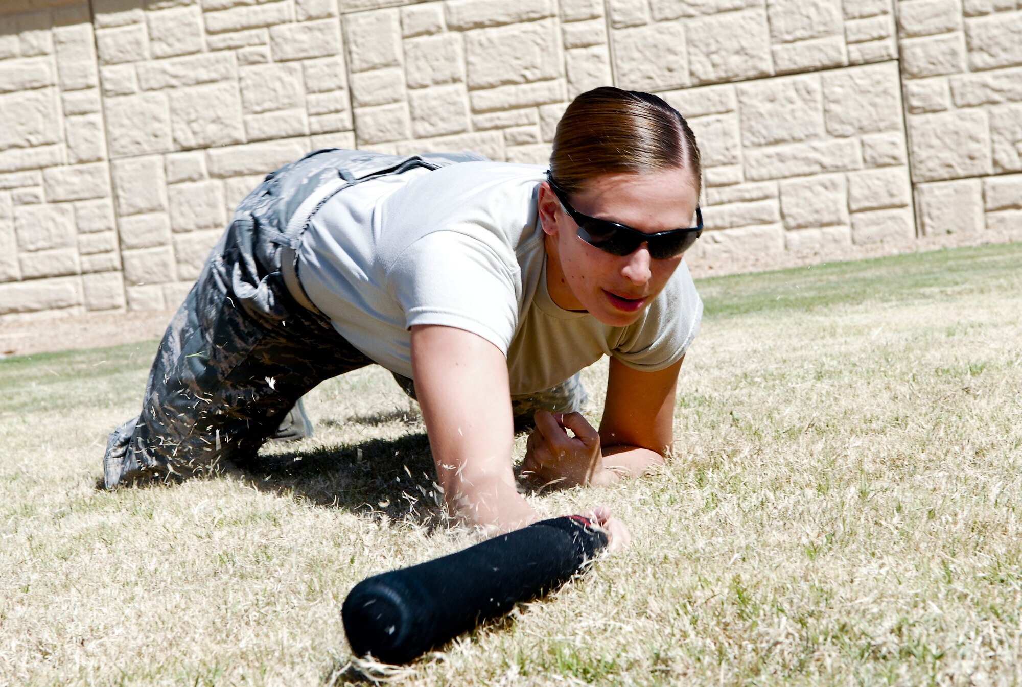 First Lt. Tyner Morales, 56th LRS Petroleum, Oil and Lubricants Flight commander, low crawls prior to using her baton training in the practical application exercise during the immersion. The officers received mission briefings, a military working dog demonstration and instruction on how to conduct a traffic stop, followed by a weapons challenge. (U.S. Air Force photo/Airman 1st Class David Owsianka)