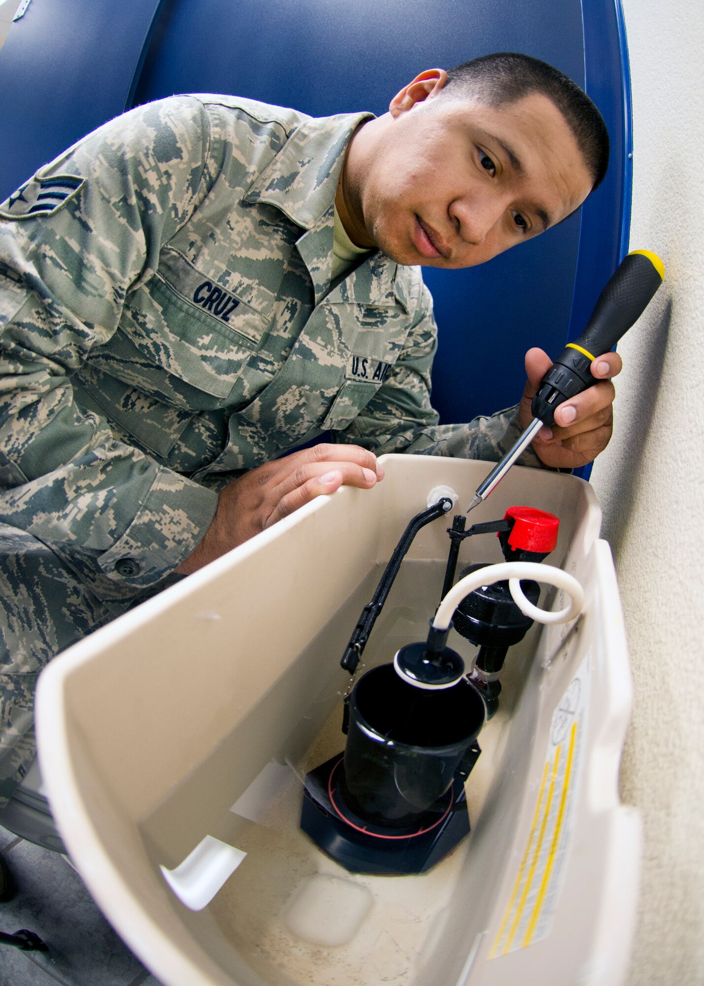 Senior Airman Lisandro Cruz Mendez, 60th Civil Engineering Squadron water and fuels maintenance journeyman, readjusts a commode tank fixture to conserve water. According to Cruz Mendez, a slowly leaking toilet can waste 1.6 gallons of water in a hour, 40 gallons in 24 hours and 1,200 gallons in 30 days.