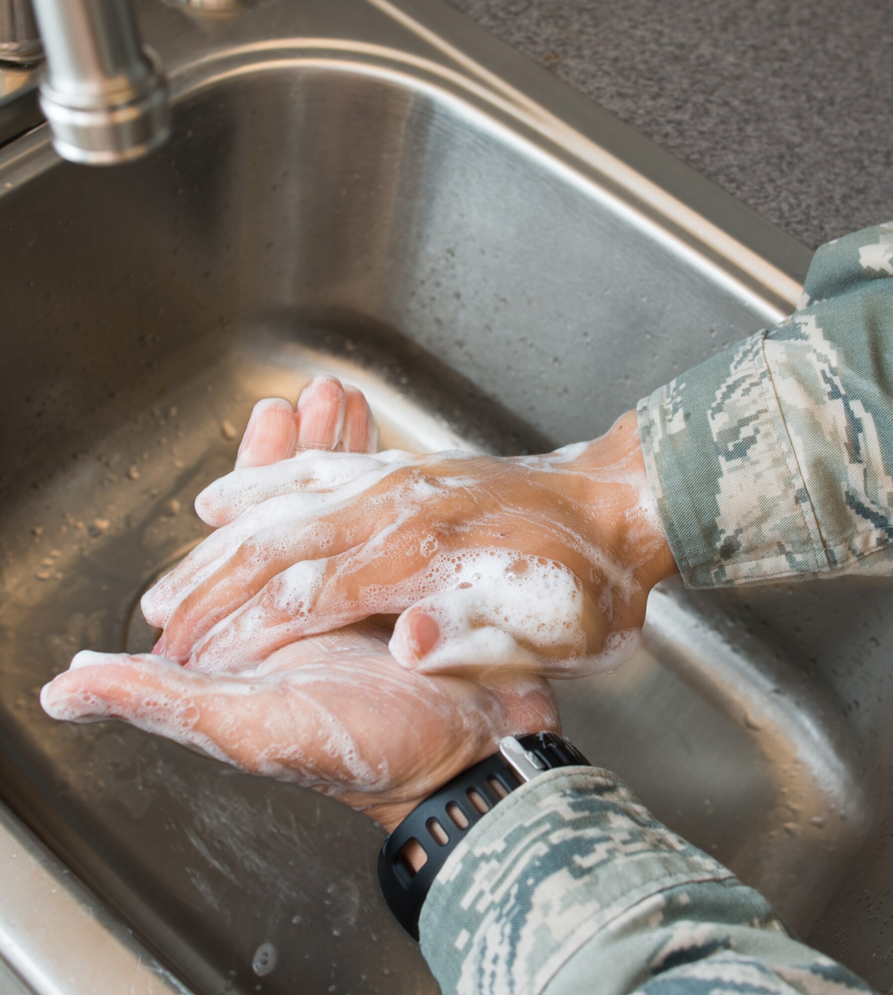 Travis Airman washes his hands while practicing good water conservation habits April 17 in the break room. Turning off the faucet while washing your hands or showering can save hundreds of gallons of water per day.