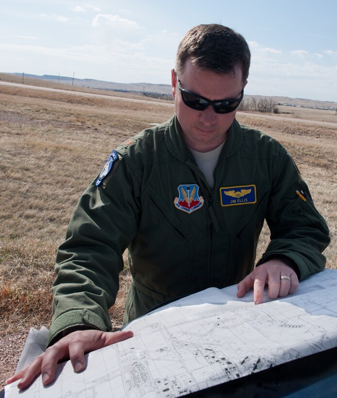 Maj. Jim Ellis, 28th Bomb Wing flight safety officer and B-1 pilot, refers to his map of the base while scanning areas for geese and ducks near the airfield on Ellsworth Air Force Base, S.D., April 4, 2013. Airmen assigned to the Bird Aircraft Strike Hazard program helps to minimize bird and wildlife strikes to aircraft. (U.S. Air Force photo by Airman 1st Class Kate Thornton/Released)
