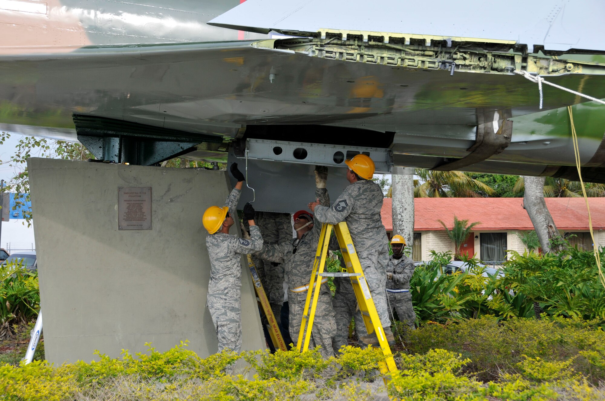 Airmen from Homestead Air Reserve Base fasten an F-4 Phantom static display, recently overhauled and restored at the base and escorted by police through the city of Homestead, Fla., to its pedestal on U.S. 1 April 12. (U.S. Air Force photo/Tim Norton)
