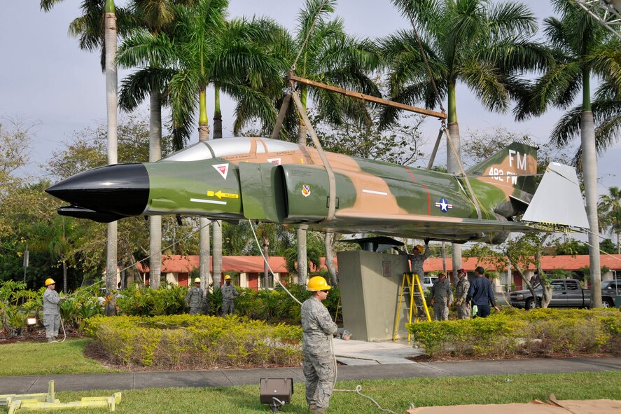 An F-4 Phantom static display, recently overhauled and restored at Homestead Air Reserve Base, Fla., and escorted by police through the city of Homestead, Fla., being hoisted back onto its pedestal by Airmen from the base on U.S. 1 April 12. (U.S. Air Force photo/Tim Norton)