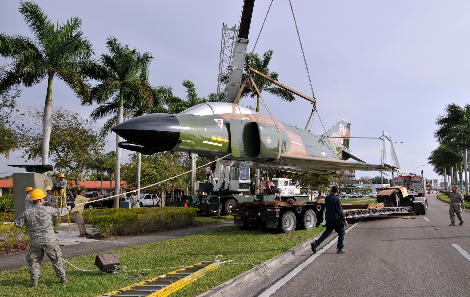 An F-4 Phantom static display, recently overhauled and restored at Homestead Air Reserve Base, Fla., and escorted by police through the city of Homestead, Fla., being hoisted back onto its pedestal by Airmen from the base on U.S. 1 April 12. (U.S. Air Force photo/Tim Norton)