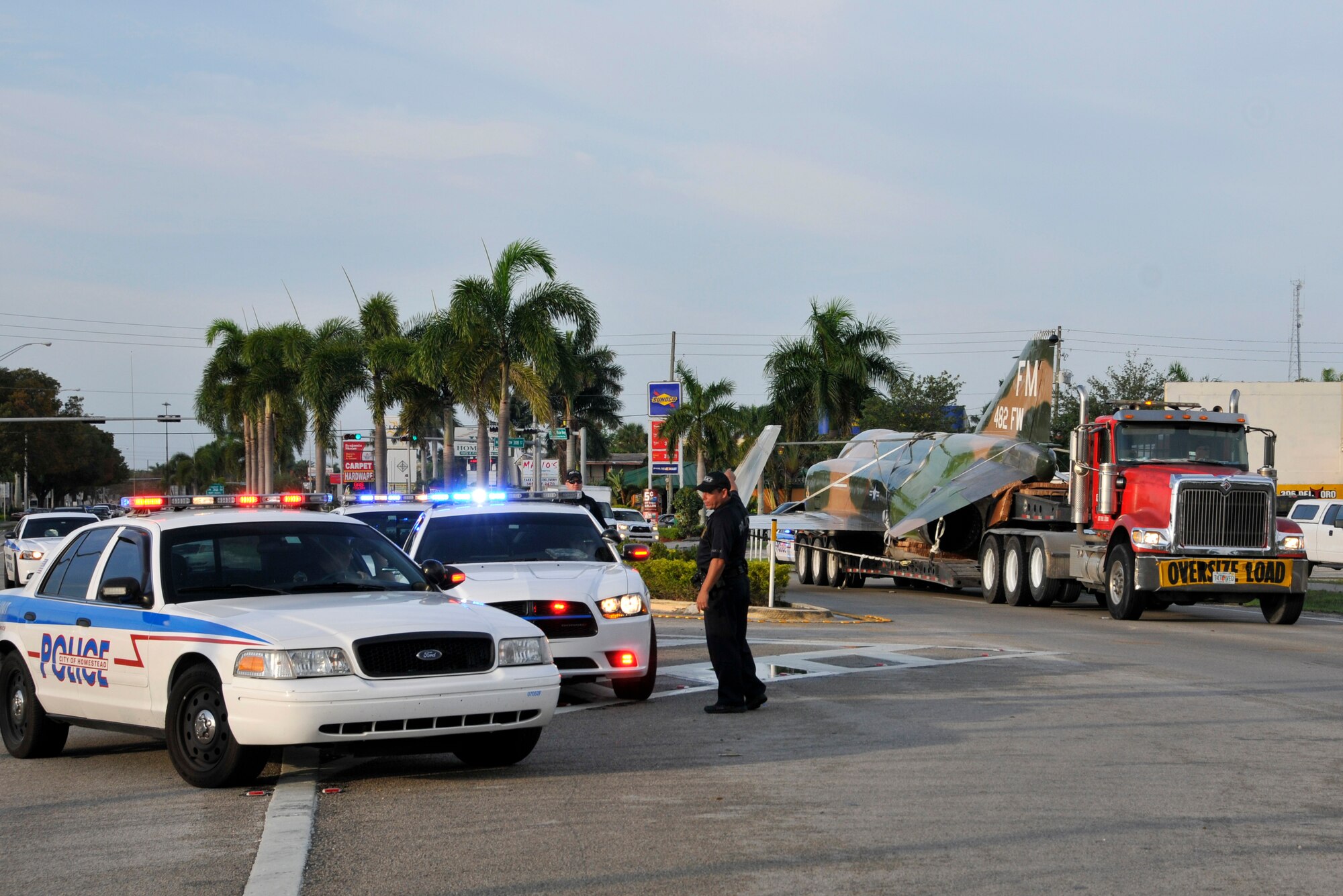 An F-4 Phantom static display, recently overhauled and restored at Homestead Air Reserve Base, Fla., escorted by police through the city of Homestead, Fla., being transported down U.S. 1 by a flatbed trailer April 12. (U.S. Air Force photo/Tim Norton)