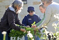 Lynda Klein, Sandra Woodall, Melody McMahon and Margie Larkin, volunteer master gardeners, check out a large celery stalk that was harvested in one of the gardens that surround the Warrior and Family
Support Center.