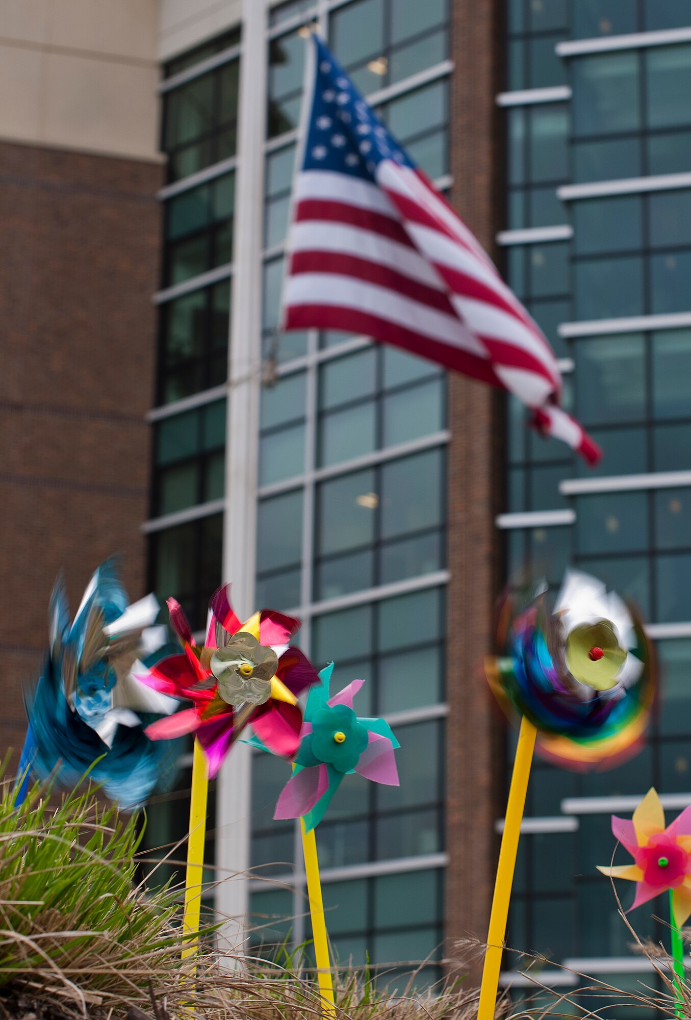 Pinwheels spin in the wind for Child Abuse Prevention month, while the flag flies at half-staff in honor of the victims of the Boston Marathon terrorist attack April 19, 2013, in front of the William A. Jones III building on Joint Base Andrews, MD. (U.S. Air Force Photo by Staff Sgt. Perry Aston)