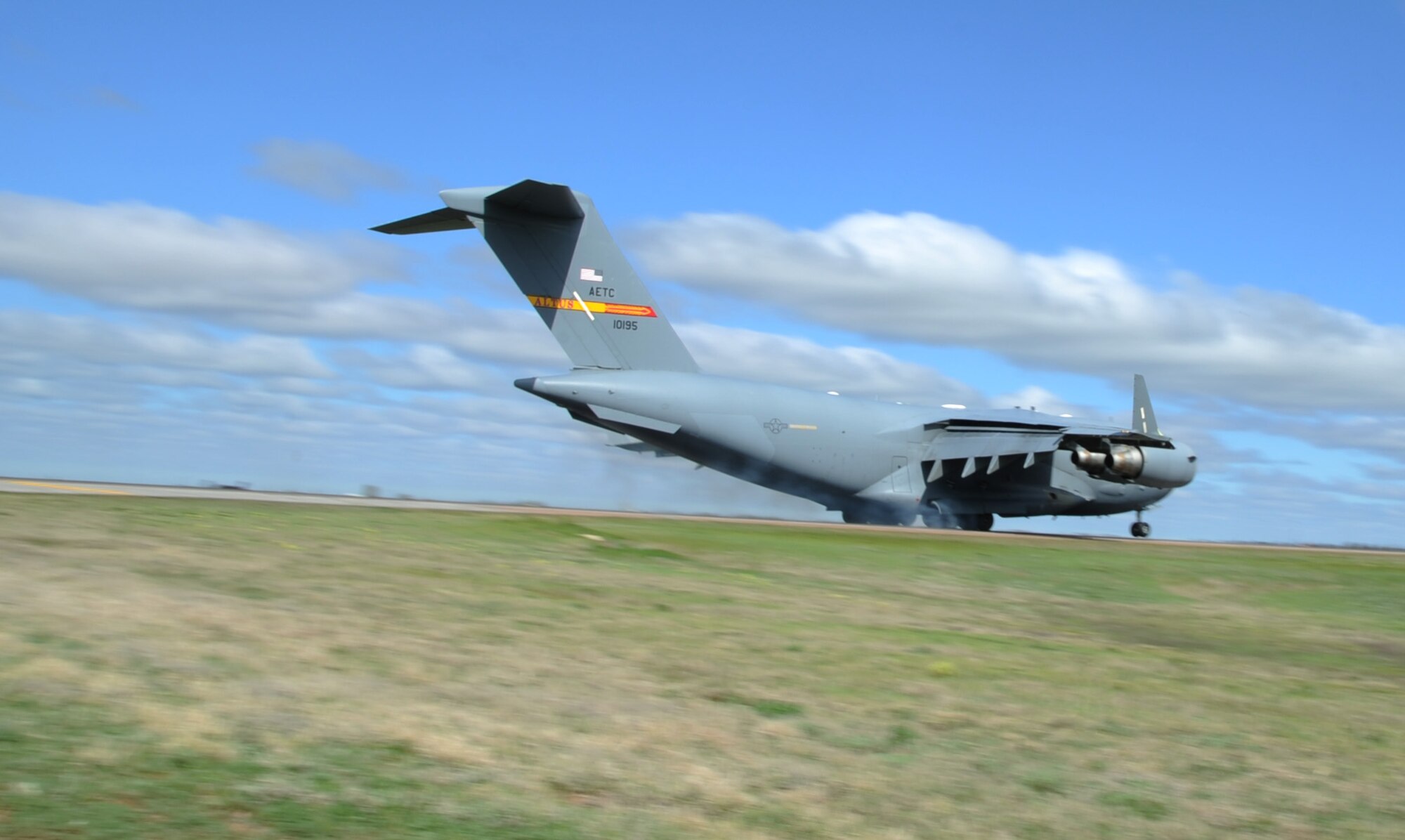 ALTUS AIR FORCE BASE, Okla. – A C-17 Globemaster III assigned to the 97th Air Mobility Wing, lands on the assault strip, April 18. The 97th Civil Engineer Squadron heavy repair shop (Dirt Boyz) poured Avion50 on the assault strip to remove rubber buildup caused by aircraft landings and swept it off, so that the flying mission could continue. (U.S. Air Force photo by Airman 1st Class Franklin R. Ramos / Released)
