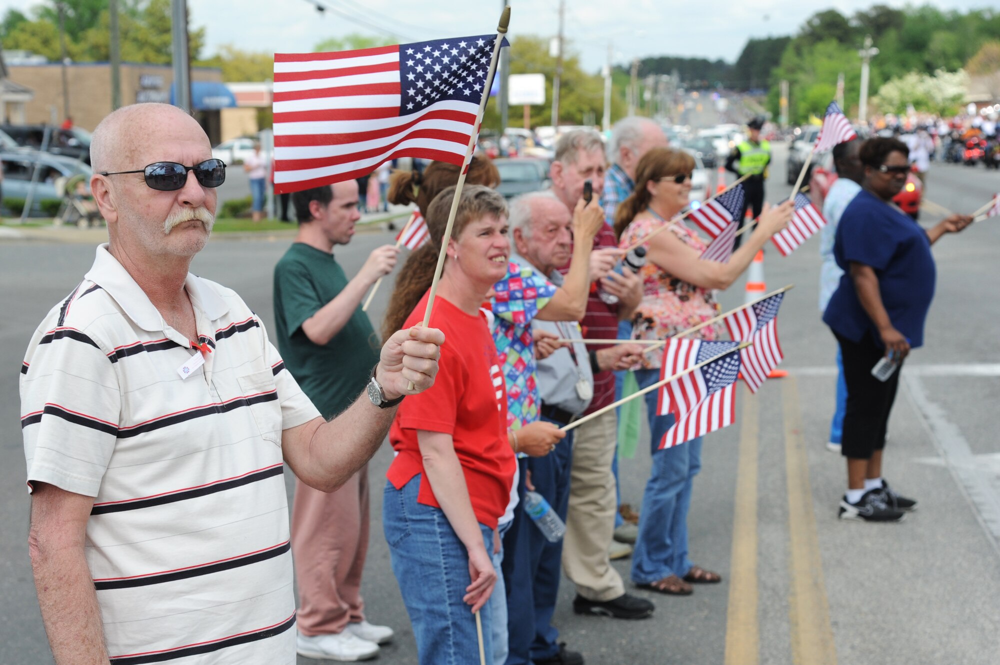 Patrons wave their flags as a group of motorcyclists usher in the Vietnam Veterans Memorial Traveling Wall to the Wayne Community College campus in Goldsboro, N.C., April 16, 2013.  Thousands of supporters lined Wayne Memorial Drive to welcome “The Wall That Heals” to Wayne County.  (U.S. Air Force photo by Airman 1st Class Brittain Crolley/Released)