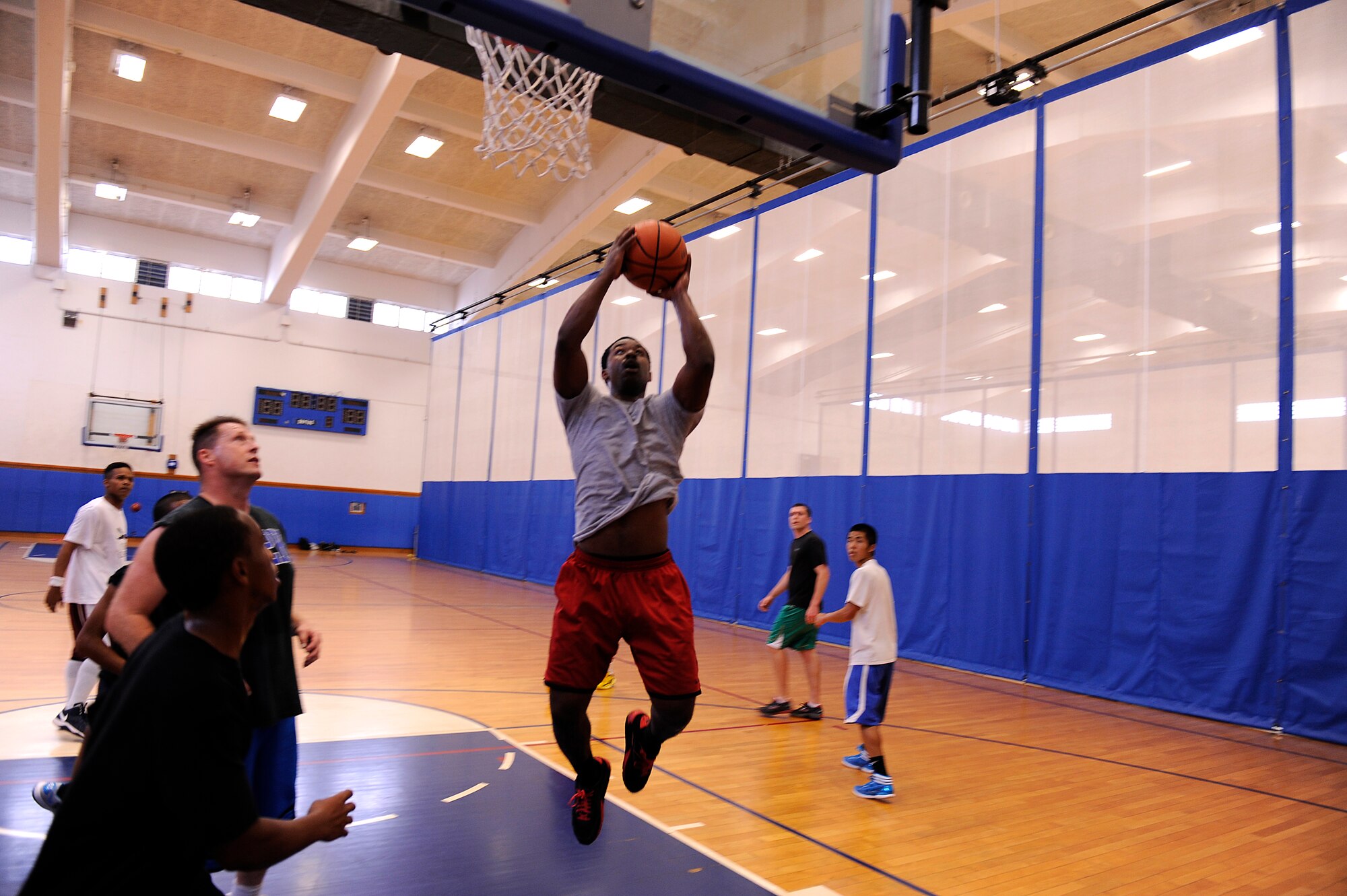 A participant in the Air Force Assistance Fund Sports Day basketball competition goes for a layup at the Risner Fitness Center on Kadena Air Base, Japan, April 12, 2013. During the event, teams from all around the base donated to the AFAF for their chance to dominate the courts in each of the tournament?s separate competitions. (U.S. Air Force photo by Senior Airman Maeson L. Elleman/Released)