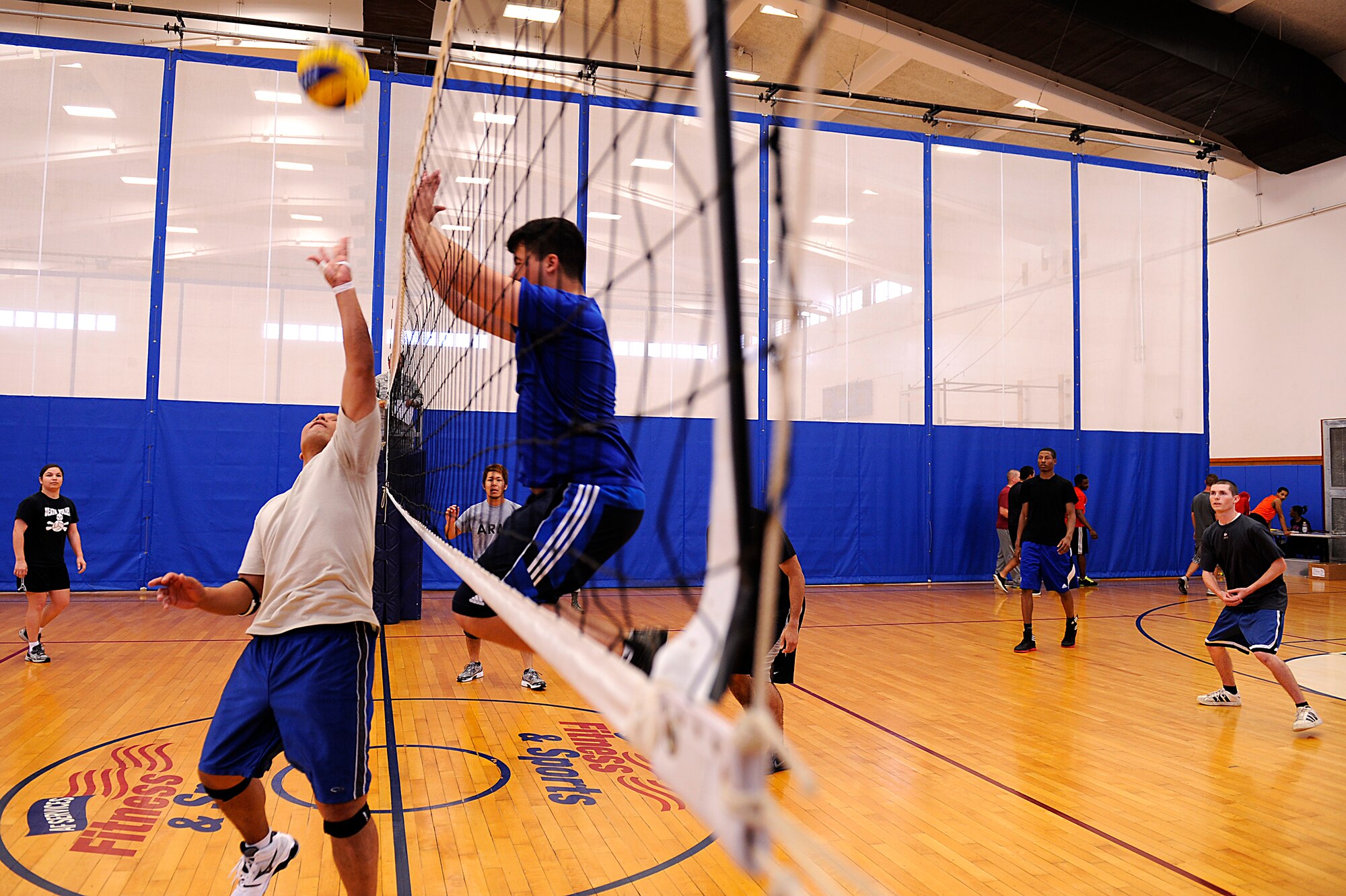U.S. Air Force Airman 1st Class Tyler Prince, 18th Wing Public Affairs broadcast journalist (center), jumps to block a volleyball during the Air Force Assistance Fund Sports Day at the Risner Fitness Center on Kadena Air Base, Japan, April 12, 2013. Twelve teams comprised of 50 people gathered at the Risner for the event, which raised roughly $500 for the AFAF. (U.S. Air Force photo by Senior Airman Maeson L. Elleman/Released)