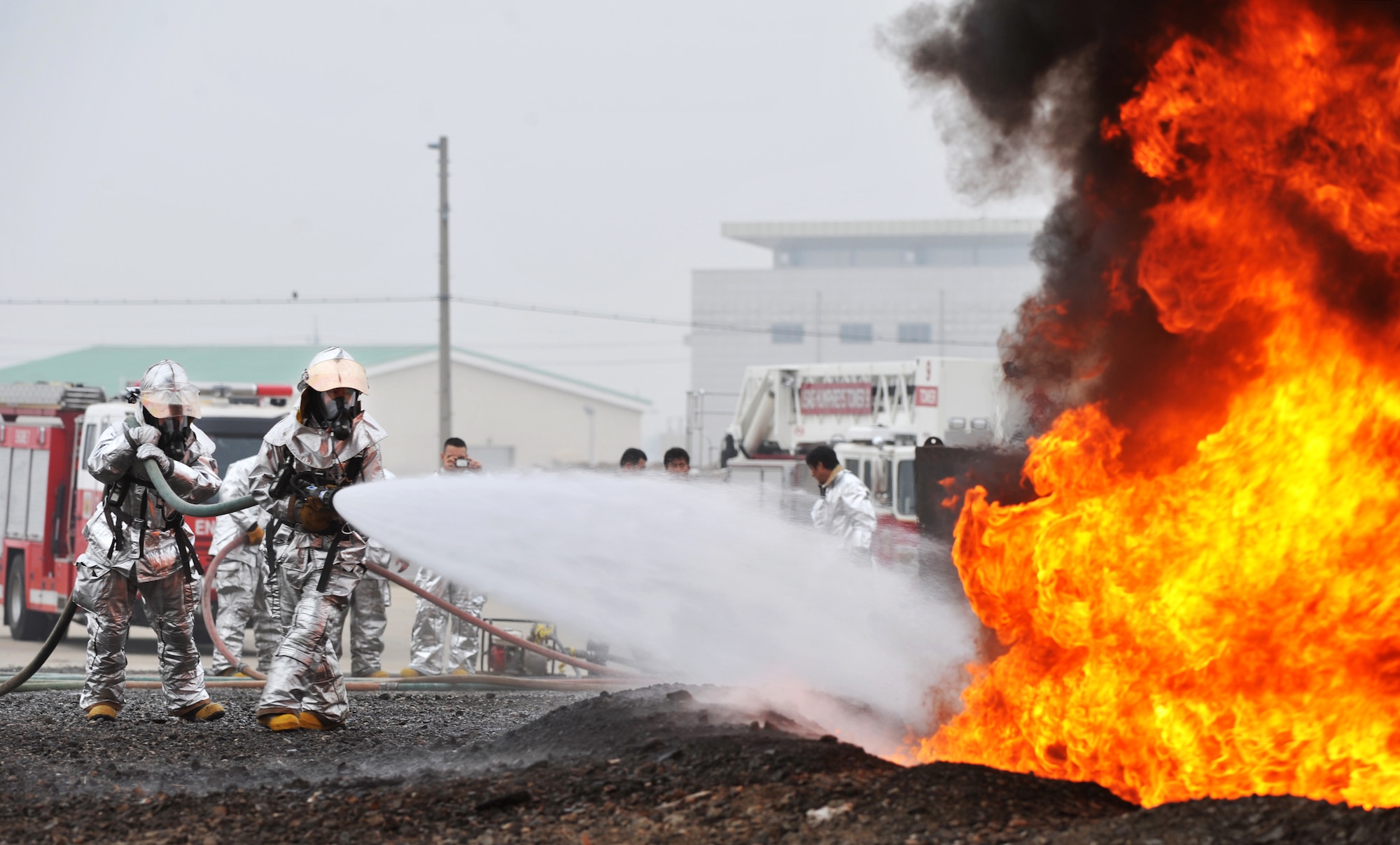 Firefighters with 51st Civil Engineer Squadron fire and emergency services flight firefighters perform a fire extinguishment during a jet-fuel fire training exercise at Camp Humphreys, Republic of Korea, April 17, 2013.  This exercise was conducted with JP-8 fuel which proved the firegighting crews a more realistic training opportunity.   (U.S. Air Force photo/Staff Sgt. Emerson Nuñez)