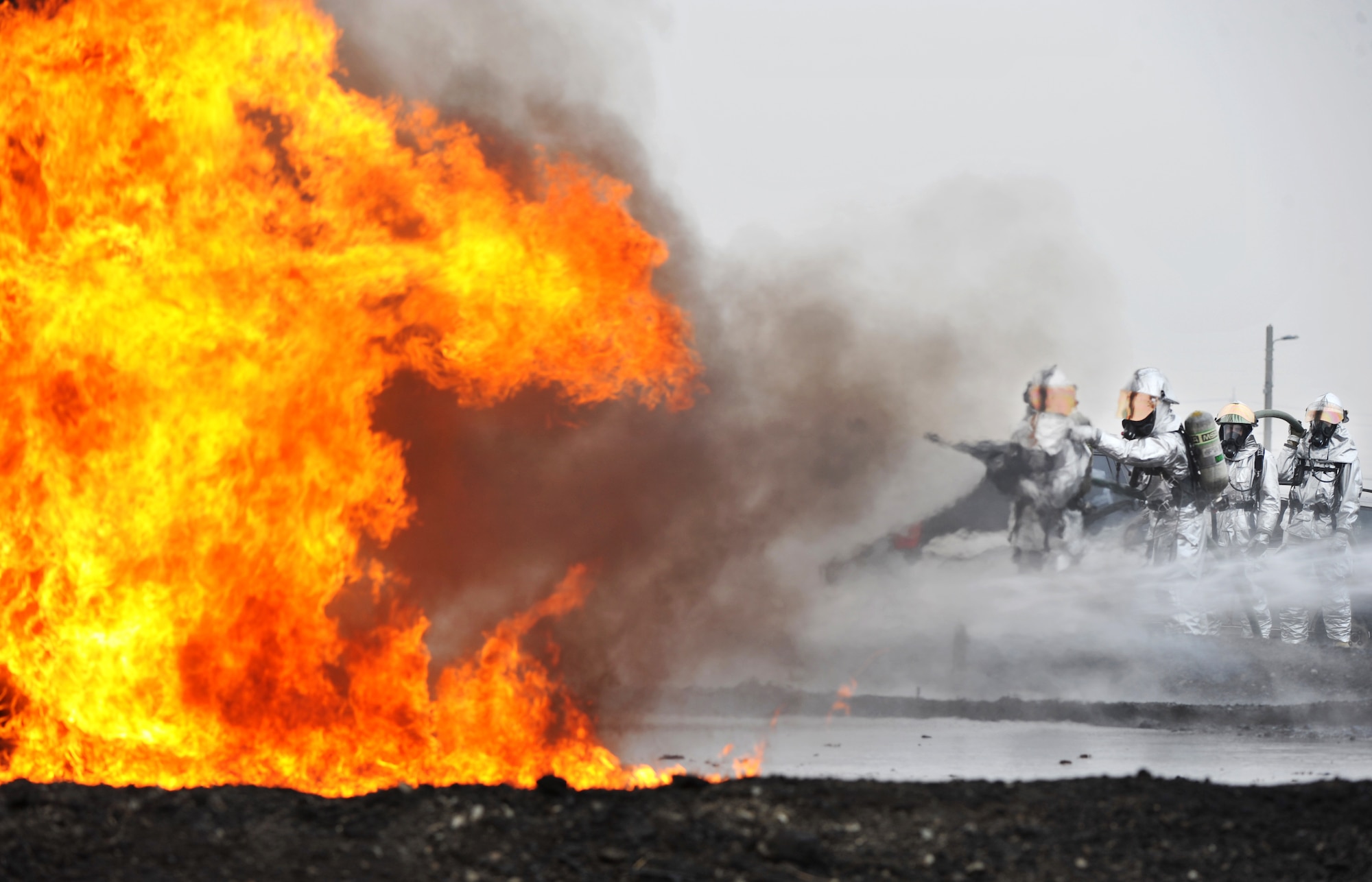 Firefighters with 51st Civil Engineer Squadron fire and emergency services flight perform a fire extinguishment during a jet-fuel fire training exercise at Camp Humphreys, Republic of Korea, April 17, 2013.  The fire is contained in a pit to prevent it from spreading out of the firefighter’s control.  (U.S. Air Force photo/Staff Sgt. Emerson Nuñez)