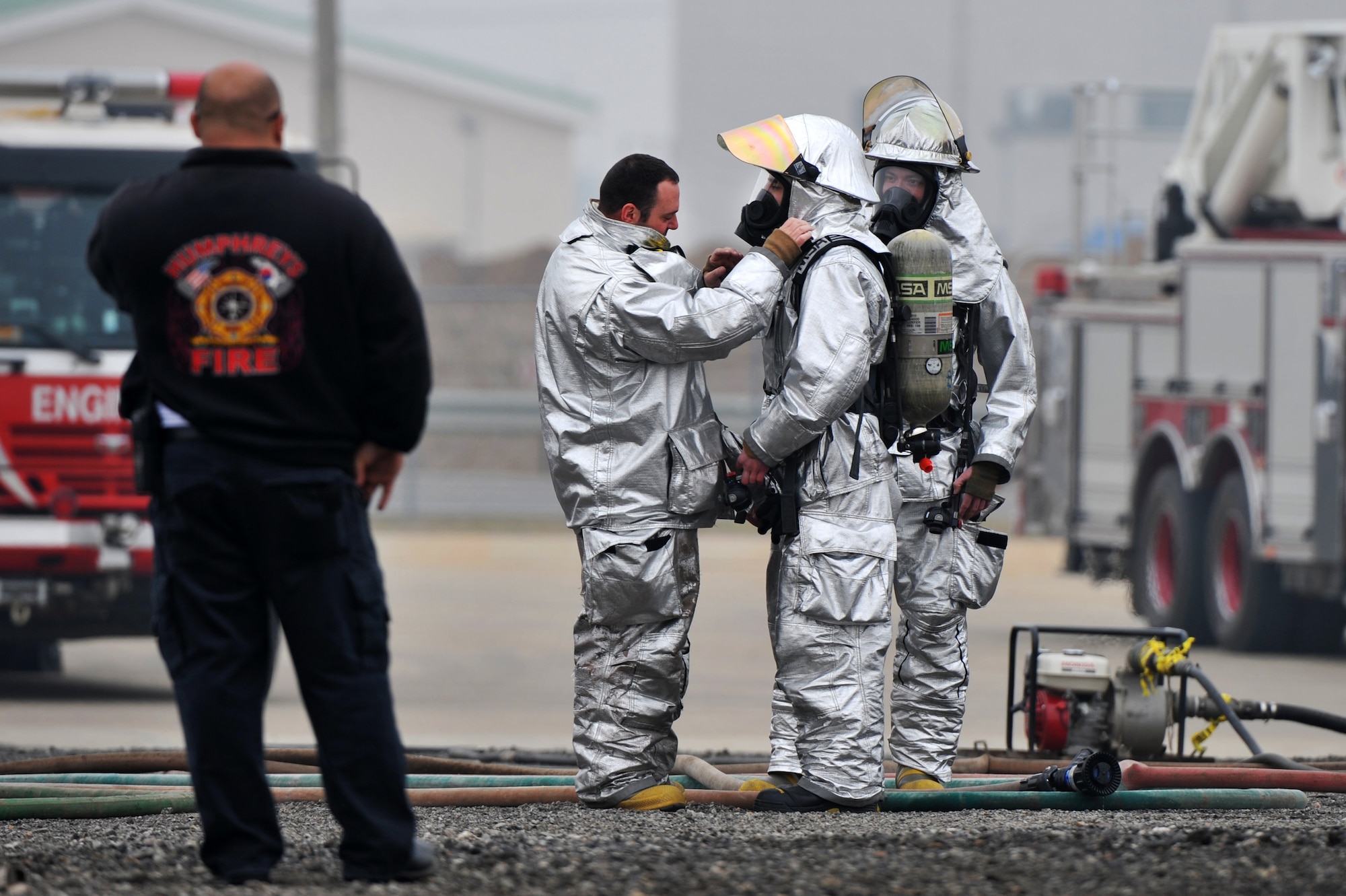 Tech. Sgt. John McLean, center, 51st Civil Engineer Squadron fire and emergency services flight B-shift station captain, performs buddy checks on Airman 1st Class Frank Boniello, 51st CES firefighter before a live fuel fire at Camp Humphreys, Republic of Korea, April 17, 2013.  As a safety measure, firefighters perform buddy checks on each other in order to ensure their gear is functioning and worn properly.  (U.S. Air Force photo/Staff Sgt. Emerson Nuñez)