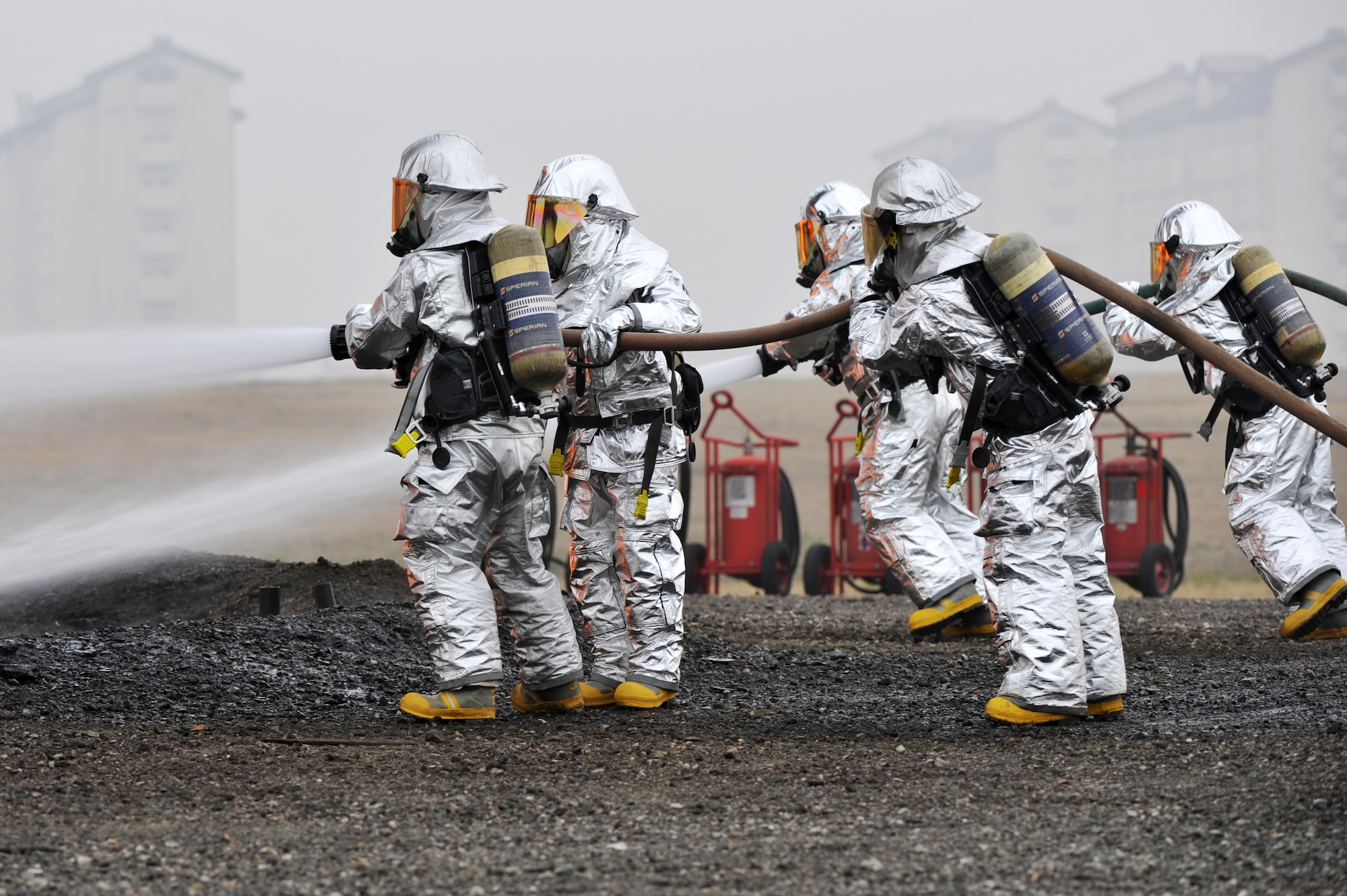Firefighters with 51st Civil Engineer Squadron fire and emergency services flight begin to extinguish a live jet-fuel fire during an exercise at Camp Humphreys, Republic of Korea, April 17, 2013.  Foam concentrate is typically used for these types of fires, but due to the high cost of the foam, they used water for the exercise.   (U.S. Air Force photo/Staff Sgt. Emerson Nuñez)