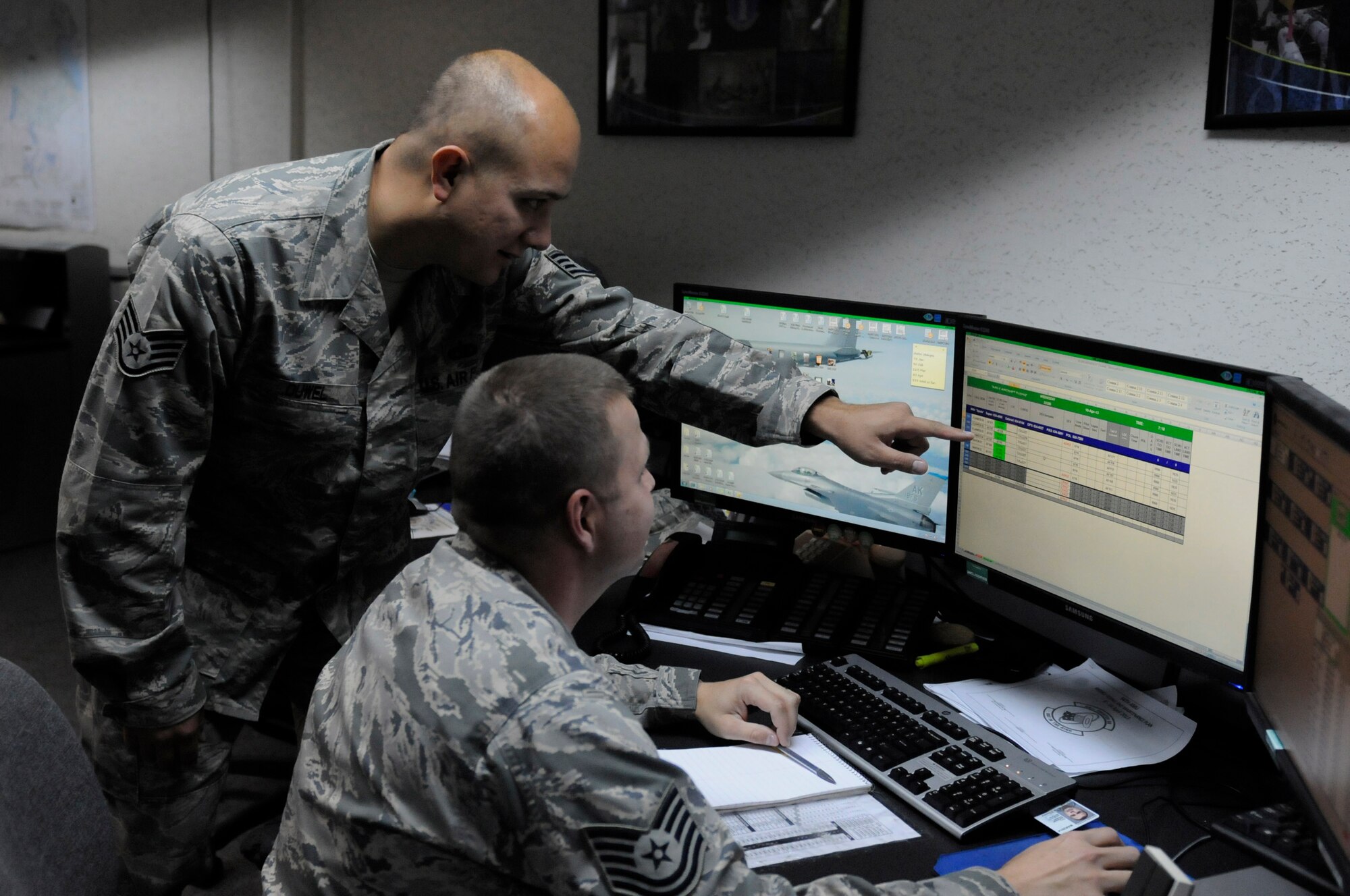 U.S. Air Force Staff Sgt. Richard Duwel, 18 Maintenance Operations Squadron weapons system controller, and Tech. Sgt. Doug Seeger, 1st Maintenance Operations Squadron weapons system controller, discuss flying deviations on Kadena Air Base, Japan, April 10, 2013. Seeger deployed to Kadena to support the F-22 Raptor squadron and worked side-by-side with Ka dena Airmen in the maintenance operations center. (U.S. Air Force photo by Staff Sgt. Rachelle C. Coleman/Released)