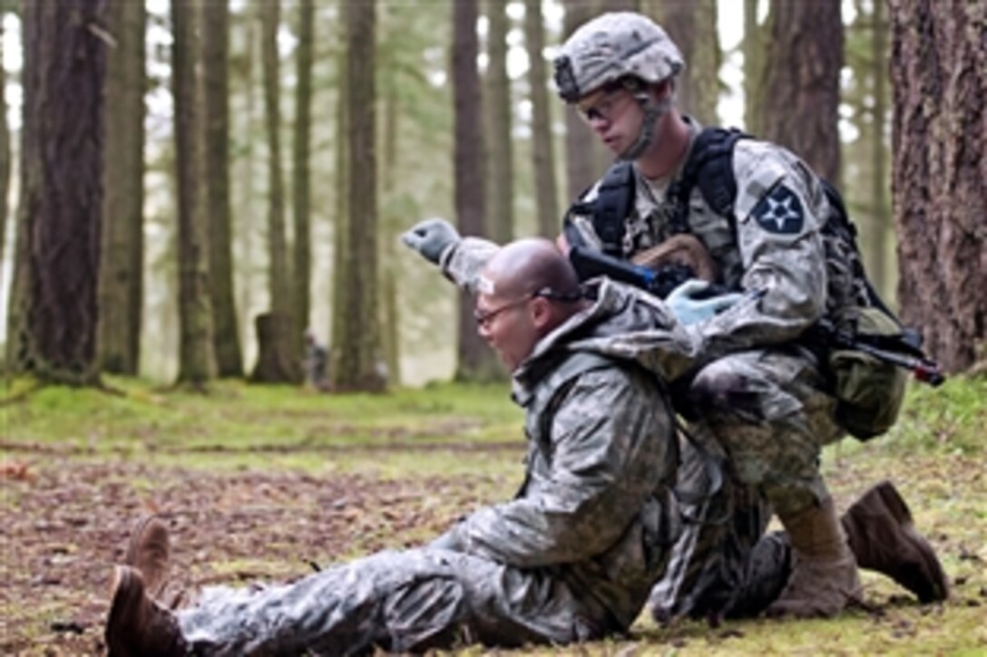 Army Sgt. Chris Swearingen, right, prepares to move a simulated casualty during testing to earn the Expert Field Medic Badge on Joint Base Lewis-McChord, Wash., April 9, 2013. Swearingen, a medic, is assigned to the 2nd Battalion, 3rd Infantry Regiment. The badge recognizes exceptional competence and outstanding performance by field medical personnel. 