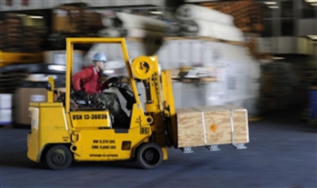 U.S. Navy Petty Officer 3rd Class Will Moseley drives a forklift through the hangar bay during weapons staging aboard the aircraft carrier USS John C. Stennis (CVN 74) as the ship operates in the Pacific Ocean on April 17, 2013.  The Stennis is deployed to the 7th Fleet area of responsibility to conduct maritime security operations and theater security cooperation efforts.  