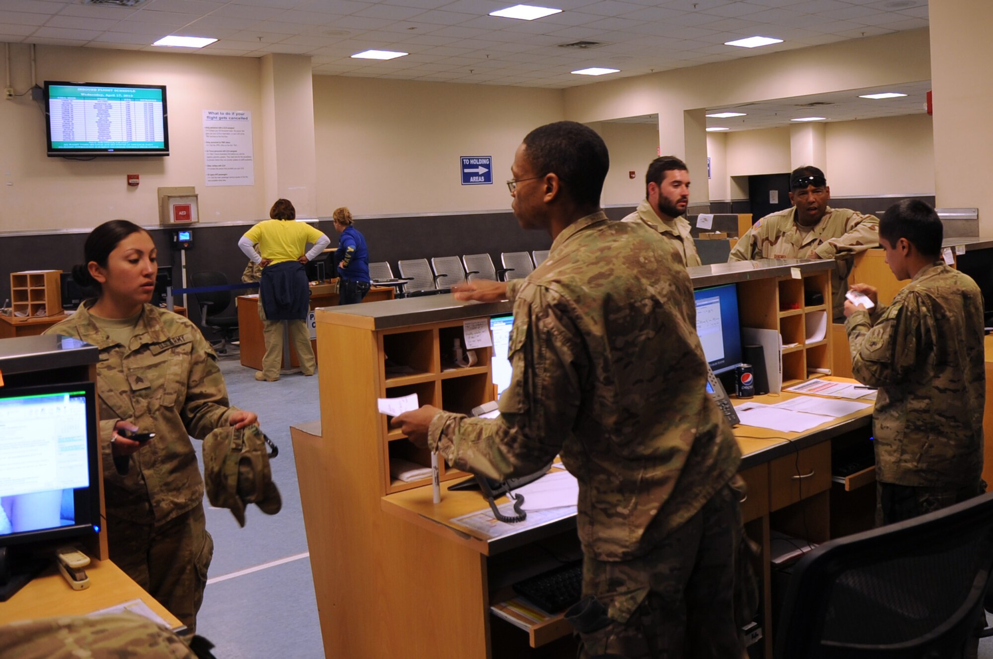 455th Expeditionary Aerial Port Squadron Airmen help passengers at the 455th EAPS passenger terminal on Bagram Airfield, Afghanistan, April 17, 2013. The terminal, the busiest in the Department of Defense, was recently reorganized to enhance security and improve customer service. (U.S. Air Force photo/Staff Sgt. David Dobrydney)