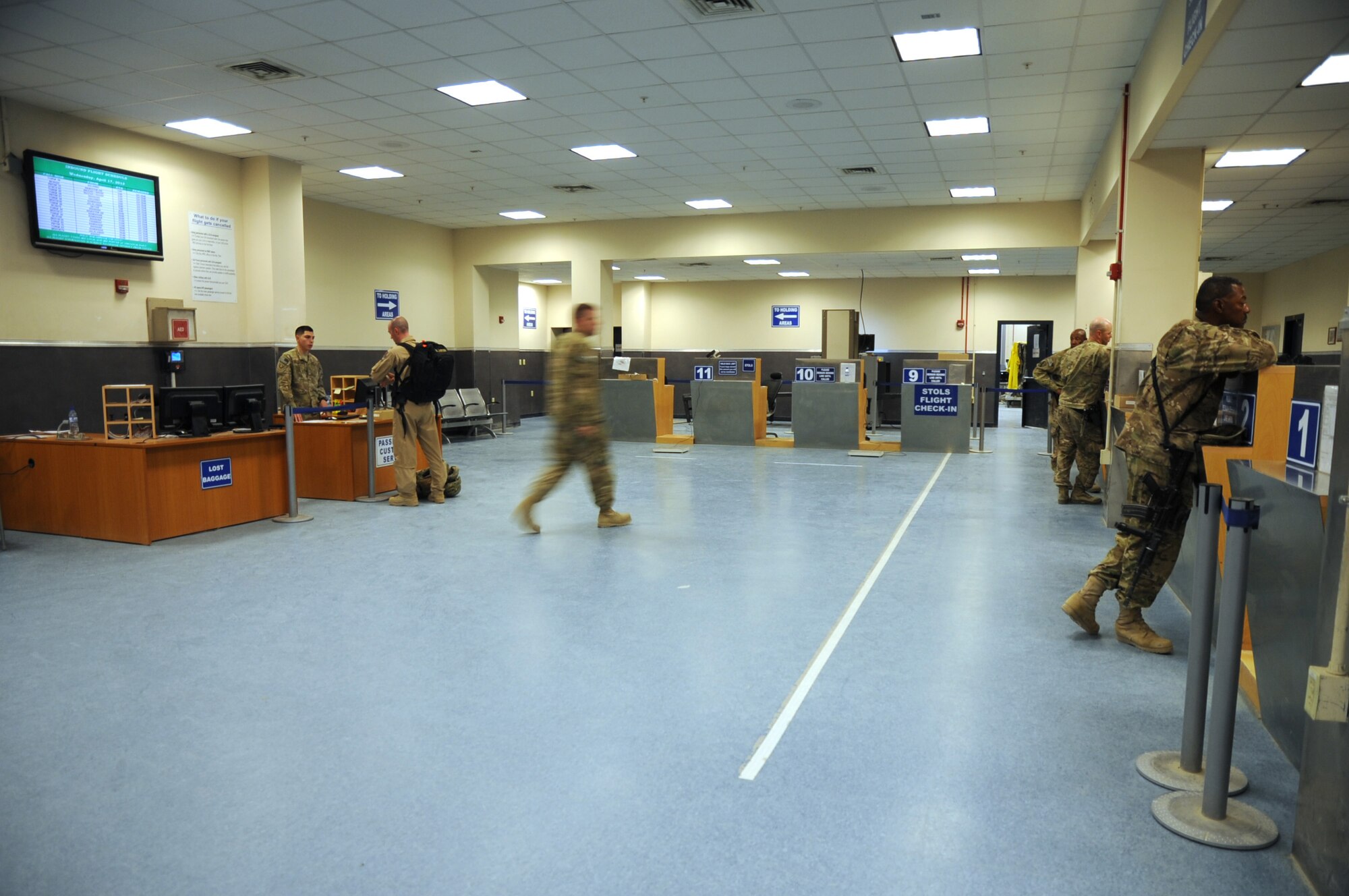 Passengers check in at the 455th Expeditionary Aerial Port Squadron passenger terminal on Bagram Airfield, Afghanistan, April 16, 2013. The 455th EAPS recently added a new customer service desk and rearranged the terminal layout to offer better security for restricted areas and improve the flow of foot traffic. (U.S. Air Force photo/Staff Sgt. David Dobrydney)