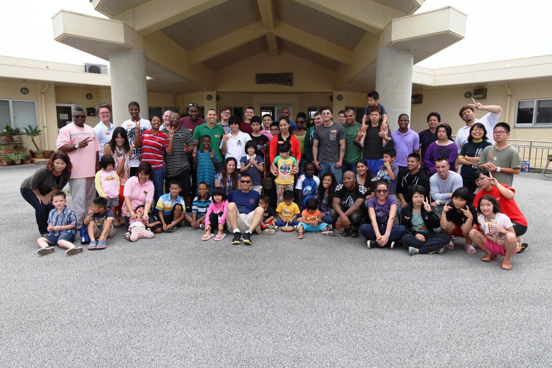Marines, Sailors, and families of Combat Logistics Battalion 31, 31st Marine Expeditionary Unit, pose for a photo with staff and students of the Nagome Orphanage and School during a visit here, April 20. Twenty-one service members and some family members donated part of their Saturday to play with local orphans, and provide an American-style barbecue of cheeseburgers and hot dogs. The Marines and Sailors of the 31st MEU are dedicated to matching their excellence in expeditionary capabilities with excellence as members of the Okinawan community.