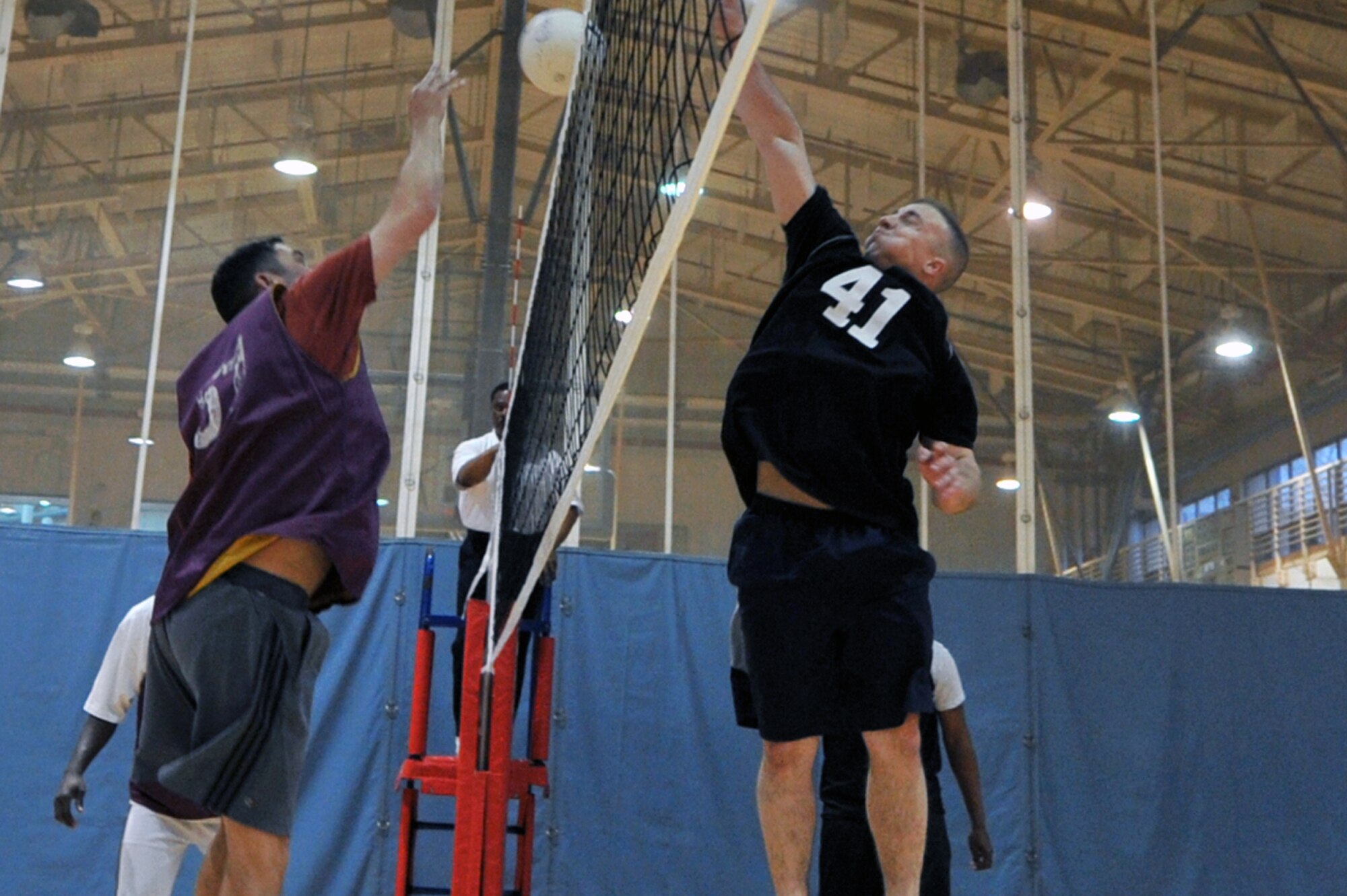 Master Sgt. David Richardson, 51st Civil Engineer Squadron NCO in charge of expeditionary engineering, goes up for the spike while members from the 5th Reconnaissance Squadron prepare to block during an intramural volleyball game at the fitness center on Osan Air Base, Republic of Korea, April 15, 2013.  The CES was victorious in the game. (U.S. Air Force photo/Senior Airman Alexis Siekert)
