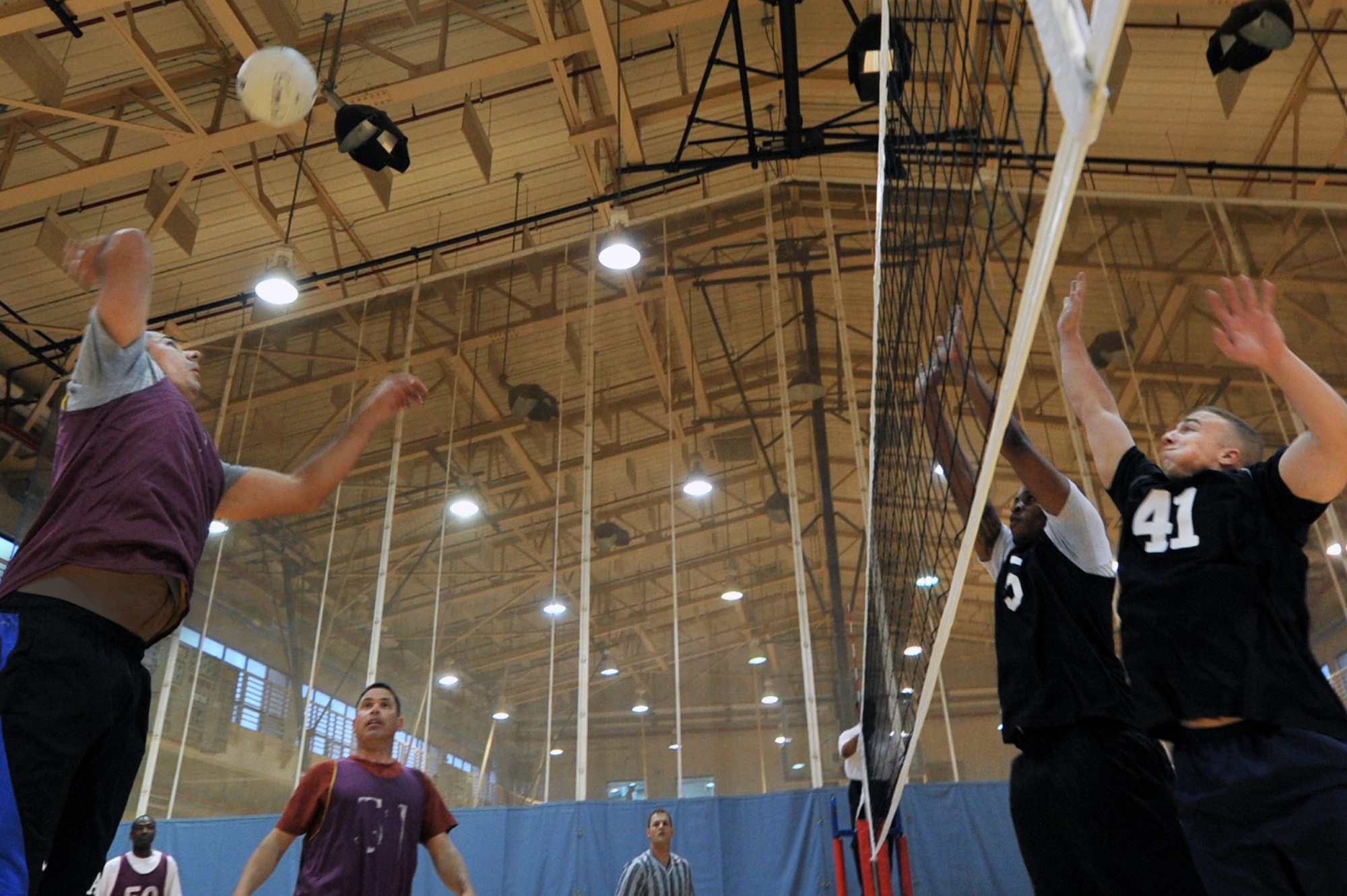 Staff Sgt. Joe Zupke, 51st Civil Engineer Squadron electrician, and Senior Airman Clarence Brooks, 5th Reconnaissance Squadron aircraft fuel systems journeyman, joust for the ball during an intramural volleyball game at the fitness center on Osan Air Base, Republic of Korea, April 15, 2013. The intramural season includes 16 teams who will compete for a slot in the tournament on May 22. (U.S. Air Force photo/Senior Airman Alexis Siekert)