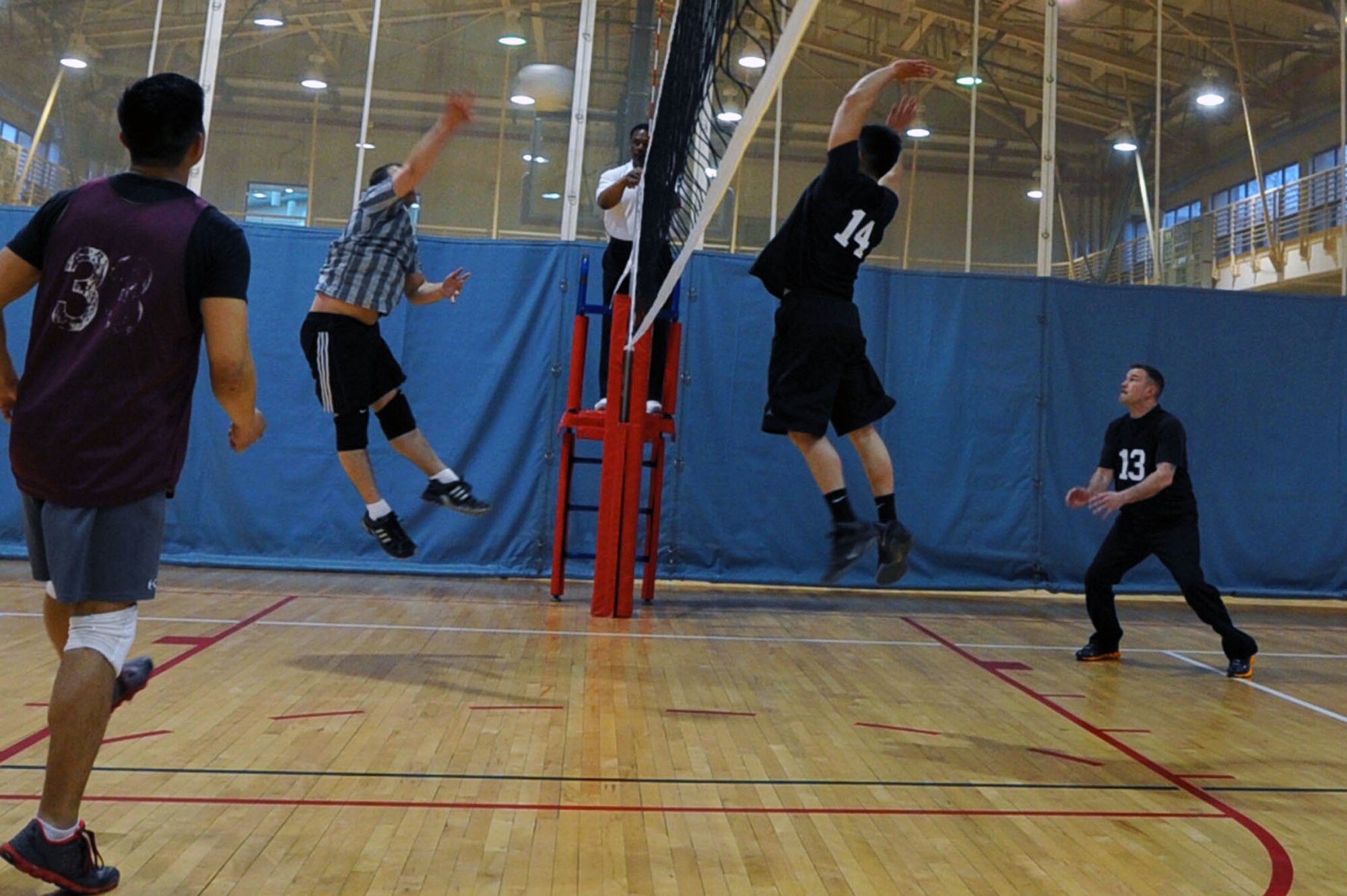Maj. Raymond Orr, 51st Civil Engineer Squadron operations flight commander, spikes a volleyball while Senior Airman David Yi, 5th Reconnaissance Squadron aircraft fuel systems journeyman, prepares to block it during an intramural volleyball game at the fitness center on Osan Air Base, Republic of Korea, April 15, 2013. This game was the first match of the season. (U.S. Air Force photo/Senior Airman Alexis Siekert)
