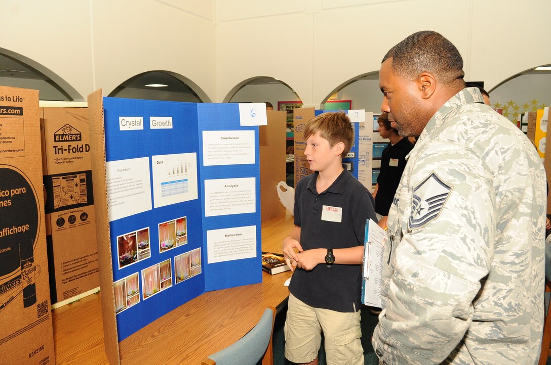 Master Sgt. Malik Franklin, 36th Munitions Squadron flight chief,  listens to a seventh grader explain his science fair project at Andersen Middle School on Andersen Air Force Base, Guam, April 4, 2013. The science fair showcased the students’ creativity and scientific knowledge. (U.S. Air Force photo by Airman 1st Class Adarius Petty/Released)