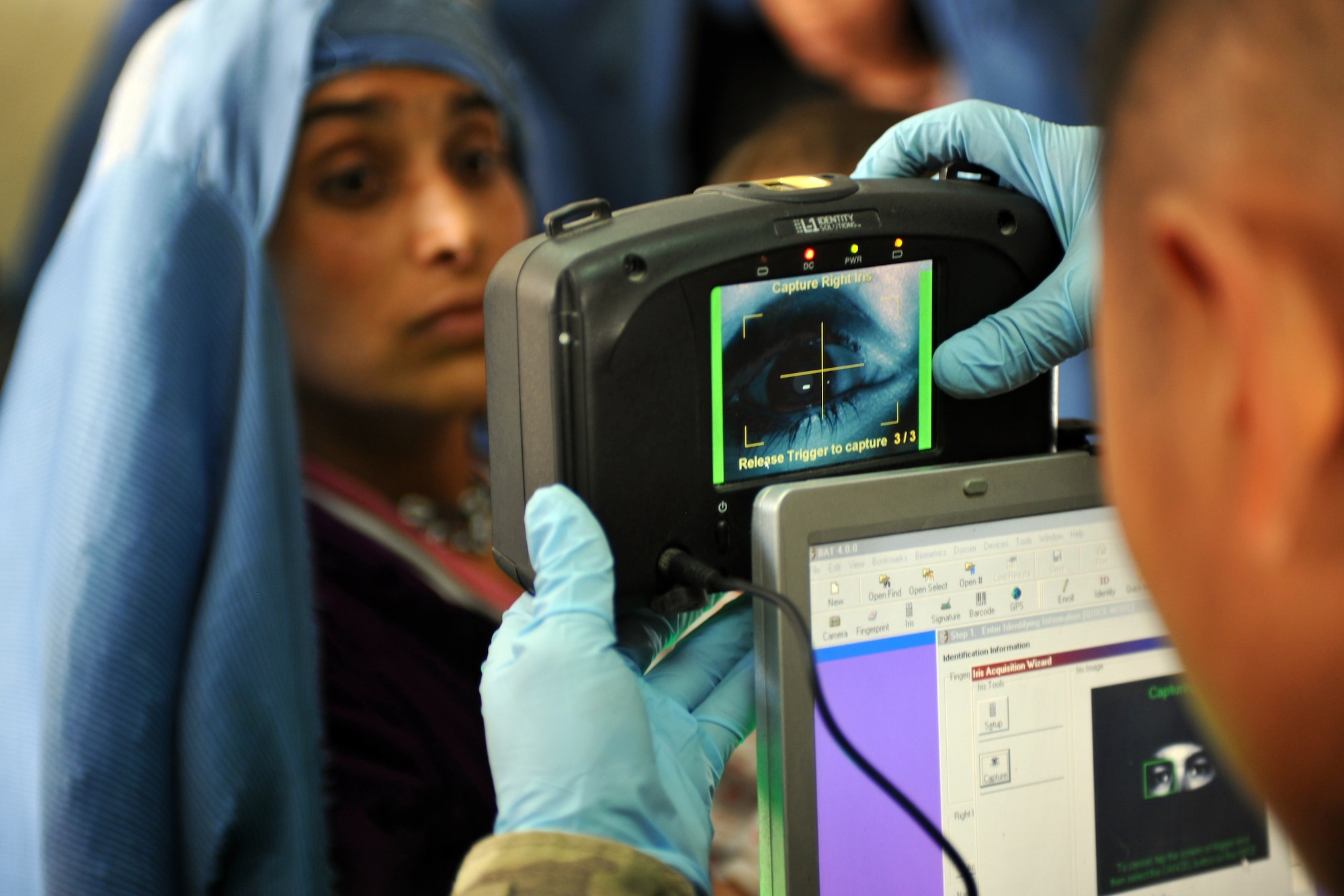 Airman 1st Class Michael Vue, 455th Expeditionary Security Forces Squadron entry controller, scans an Afghan woman's iris in the waiting area of the Egyptian Hospital at Bagram Airfield, Afghanistan, April 16, 2013. Medical teams use biometrics to identify and track the records for all incoming patients by scanning their iris and fingerprints and then inputting the information into a database.  (U.S. Air Force photo/Senior Airman Chris Willis)
