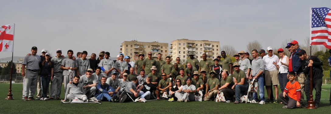 Marines assigned to the Georgia Training Team and the Republic of Georgia National team, pose for a picture after the benefit baseball game to honor the Georgian soldiers who were injured in Afghanistan while supporting the International Security Assistance Force. 
