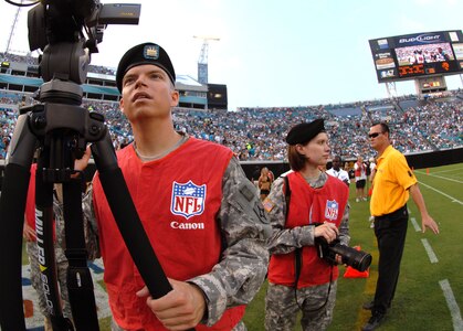 Spc. James Cornwell (left) and Staff Sgt. Blair Heusdens of the 107th Mobile Public Affairs Detachment videotape and shoot photos of the Jacksonville Jaguars pre-season NFL game at the Jacksonville Municipal Stadium in Jacksonville, Fla., Aug. 9, 2008.