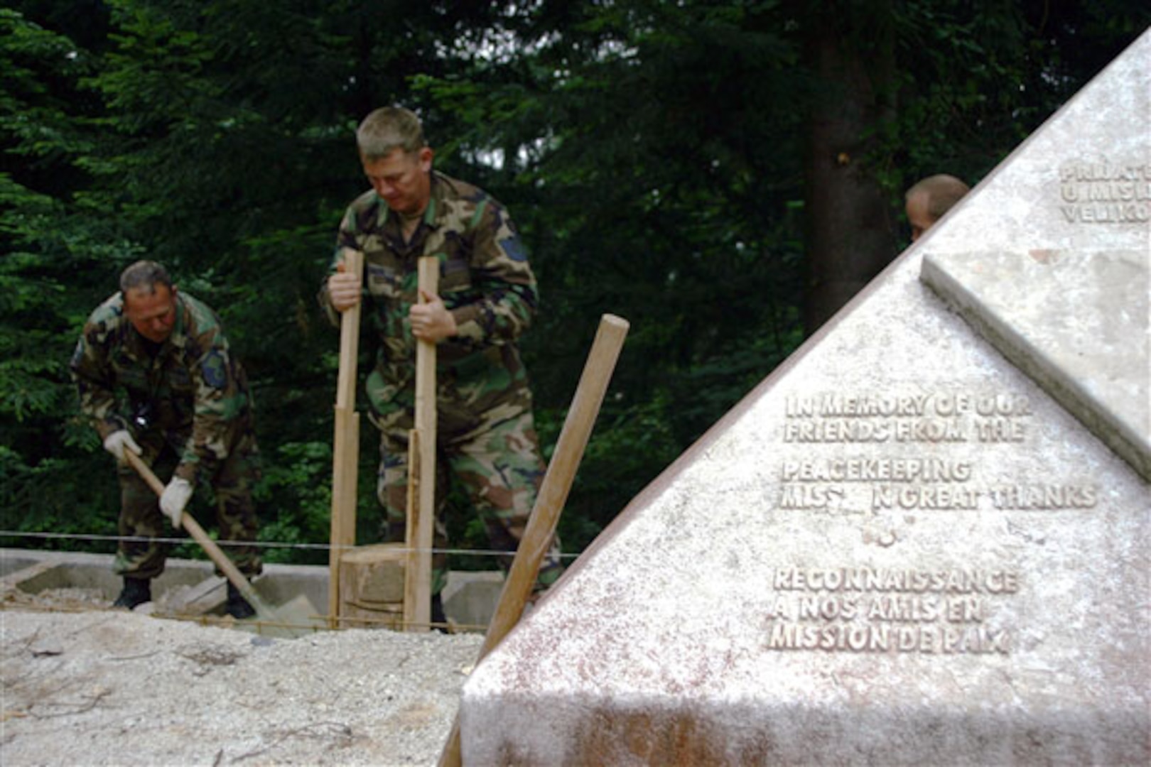 Air Force Master Sgt. Robert A. Gordon and Tech. Sgt. Shaun Blische of the Maryland Air National Guard's 175th Civil Engineer Squadron, restore a monument at Mount Igman, Bosnia and Herzegovina. The monument memorializes three American diplomats and their French driver, who were killed at the site in 1995. The memorial is being restored as part of a humanitarian civic action project under the National Guard's State Partnership Program.
