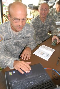 Chief Warrant Officer Tom Marsh (left) and 1st Sgt. Kyle Heidenreich work on a preliminary deployment kit during a Logistics Enablers Overview Course Aug. 15 in Bismarck, N.D. Marsh uses the laptop to write information to the green tag, which will track equipment. The kit is one of several pieces of equipment covered during the weeklong course that included Soldiers from across the United States.