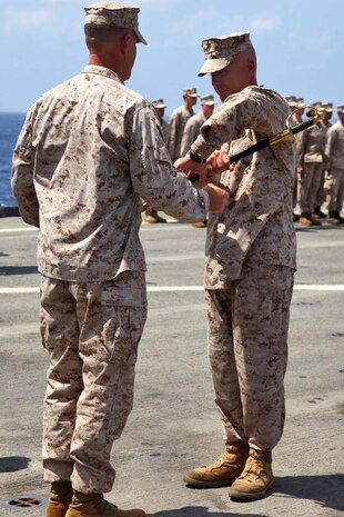 USS RUSHMORE (April 13, 2013) Sergeant Maj. JohnPaul Doring, sergeant major, Combat Logistics Battalion 15, 15th Marine Expeditionary Unit, accepts a non-commssioned officer’s sword from Lt. Col. John Wiener, commanding officer, CLB-15, 15th MEU, symbolizing his role as the senior enlisted Marine during a relief and appointment ceremony on the flight deck of USS Rushmore, April 13. The ceremony welcomed Doring and bid farewell to 1st Sgt. Bradley Simmons. The 15th MEU is comprised of approximately 2,400 Marines and sailors and is deployed as part of the Peleliu Amphibious Ready Group. Together, they provide a forward-deployed, flexible sea-based Marine Air Ground Task Force capable of conducting a wide variety of operations ranging from humanitarian aid to combat. (U.S. Marine Corps photo by Cpl. Timothy Childers/Released)