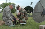 Checking the signal: Tech. Sgt. Bill Smith, left, practices aligning a satellite with the help of Staff Sgt. Scott Roach. The men are members of the Arkansas Air Guard's 154th Weather Flight, which provided weather support to the Arkansas Army Guard's 1st Battalion, 114th Security and Support during their recent annual training. The 154th is tasked to support the 114th with a five-man crew in the event of a call up to the Gulf Coast states in response to natural disaster. "This [annual training] will give us a chance to exercise our abilities to support them in the event of a deployment or call up," said Master Sgt. Paul Wilkerson, 154th Weather Flight NCO-in-charge (NCOIC).