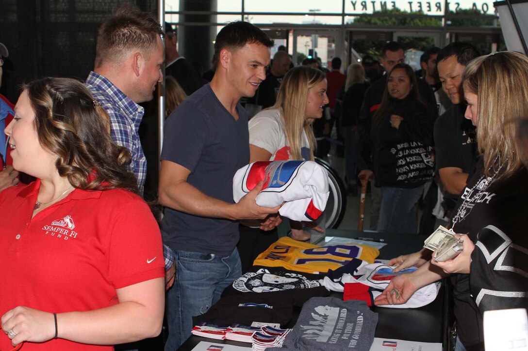 Patriots Hockey assistant captain, Jeremy Pilachowski, sells Patriots Hockey merchandise after a game against the Los Angeles County Sheriff's Department at the STAPLES Center here, April 18, 2013. Pilachowski, an active duty Marine infantry officer and native of Chicago, is one of the founders of the team and has helped organize many fundraising events. Patriots Hockey raised money for the Semper Fi Fund by selling t-shirts, jerseys and other Patriots Hockey gear at the STAPLES Center that evening. The team is dedicated to serving the military community by raising funds and awareness for nonprofit organizations.