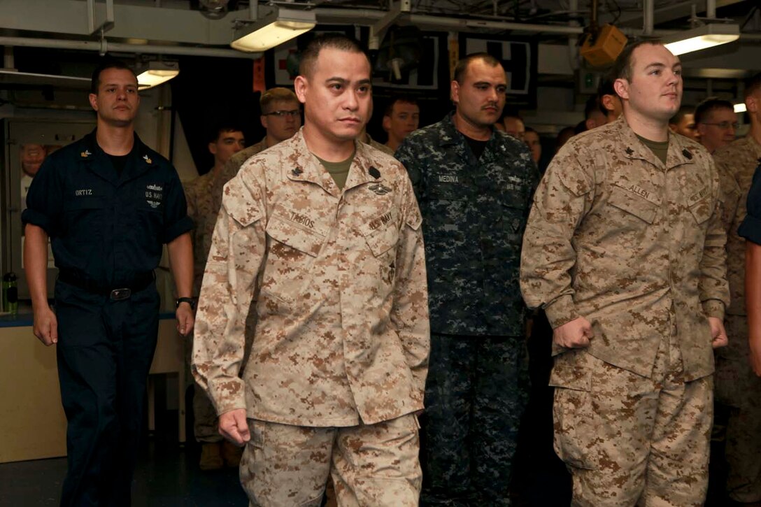 Hospital Corpsman 2nd Class Wendell Tabios (center), Command Element, 15th Marine Expeditionary Unit, and Hospital Corpsman 1st Class Marcos A. Ortiz (left), USS Peleliu, march to the front of a formation during an award ceremony held in the ship’s medical facility, April 20. The 15th MEU is deployed as part of the Peleliu Amphibious Ready Group and is comprised of approximately 2,400 Marines and sailors. Together with Amphibious Squadron Three, they provide a forward-deployed, flexible sea-based Marine Air Ground Task Force capable of conducting a wide variety of operations ranging from humanitarian aid to combat. Tabios, 36, is from Cavite, Philippines, and Ortiz, 32, is from North Bergen, N.J. (U.S. Marine Corps photo by Cpl. John Robbart III/Released)