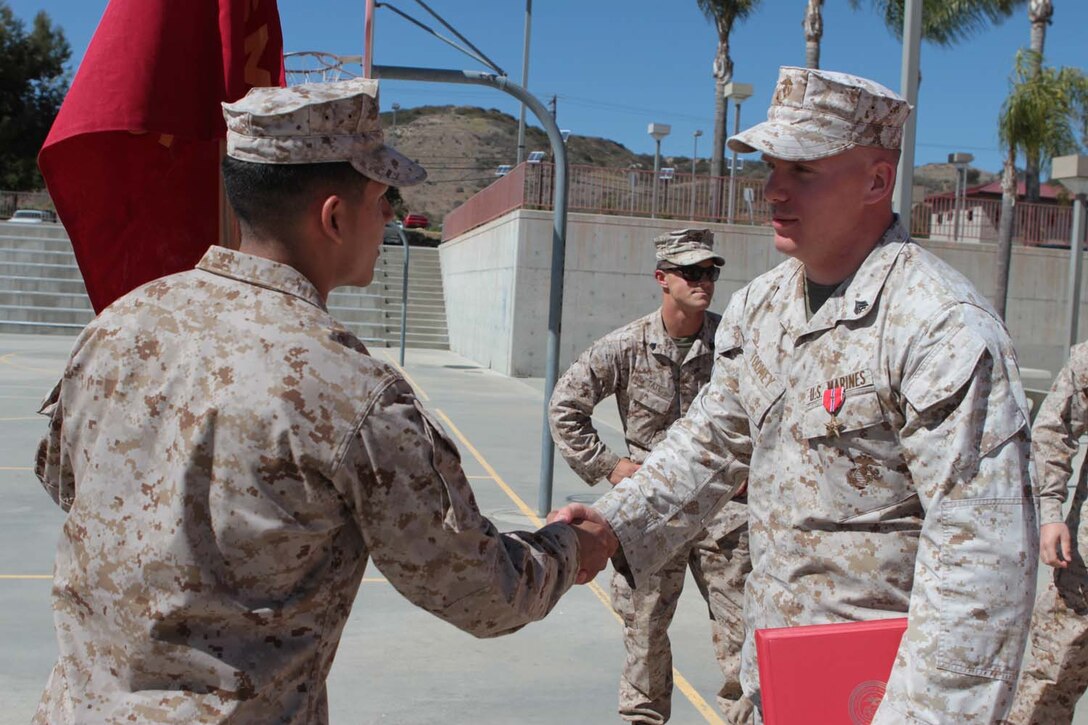 Corporal Michael P. Toomey, a rifleman serving with 2nd Battalion, 5th Marine Regiment, receives congratulations from a fellow Marine after receiving the Bronze Star Medal with a Combat V during a ceremony here, April 18, 2013. Toomey, a native of San Francisco, was recognized for his heroic actions on May 8, 2012, while deployed to Musa Qal'ah district, Helmand province, Afghanistan. He led a fire team of Marines in a hasty ambush against an insurgent machine gun team hiding in a tree line. During the assault, Toomey shot an enemy fighter and threw a grenade at their position, causing the remaining insurgents to flee and abandon fighting the Marines for the remainder of the operation.