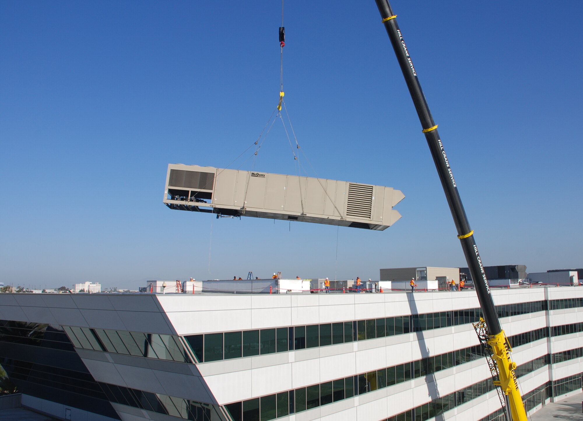 A heating and heating and air conditioning unit is removed from at top a building on Los Angeles AFB, April 20.  (Courtesy photo)